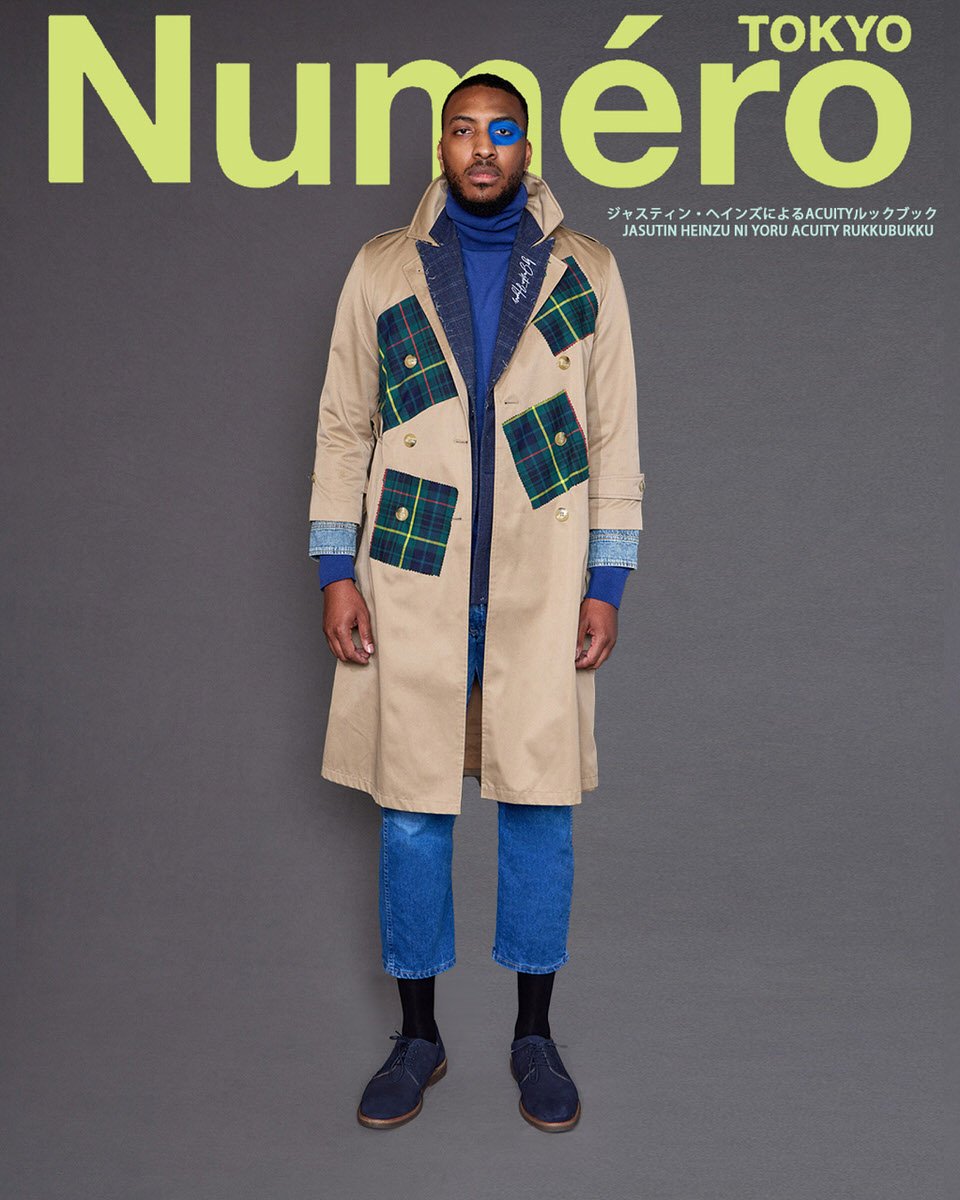 JUS10H by Justin Haynes ACUITY Collection menswear look for Numéro Tokyo by Scott Parker — male model in tan trench coat with green tartan patch pockets and signature embroidery, layered over royal blue turtleneck, paired with light wash cropped jean
