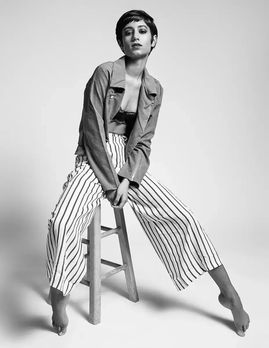 Eloissa, black and white, leaning forward on stool, striped wide-leg trousers and suede jacket, black lace bralette, East Williamsburg studio test shoot, makeup by Schanica Pickens, photographed by Scott Parker Photo