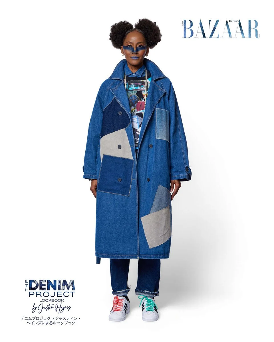 JUS10H Denim Project 2025 Harper's Bazaar Japan lookbook — model in oversized medium-wash denim patchwork trench coat with large grey contrast panels over graphic print layered denim shirt and straight-leg jeans, multicolor-laced Adidas Superstar sne