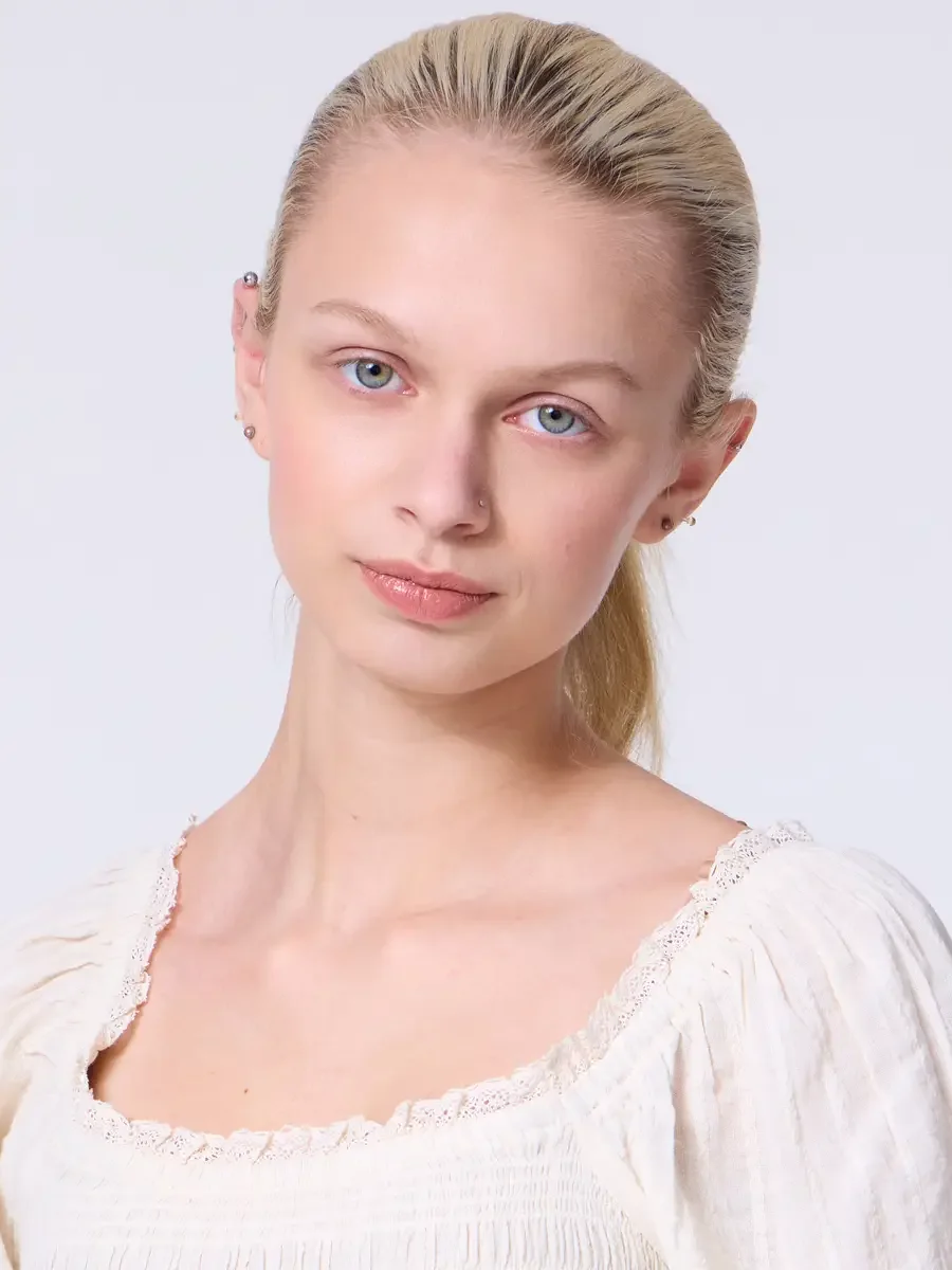 Model portfolio development session, commercial look, cream smocked square-neck puff-sleeve crop top with lace-trimmed neckline, close-crop, hair pulled back sleek, direct gaze slightly off-axis, smocking and lace trim detail at neckline visible, lig