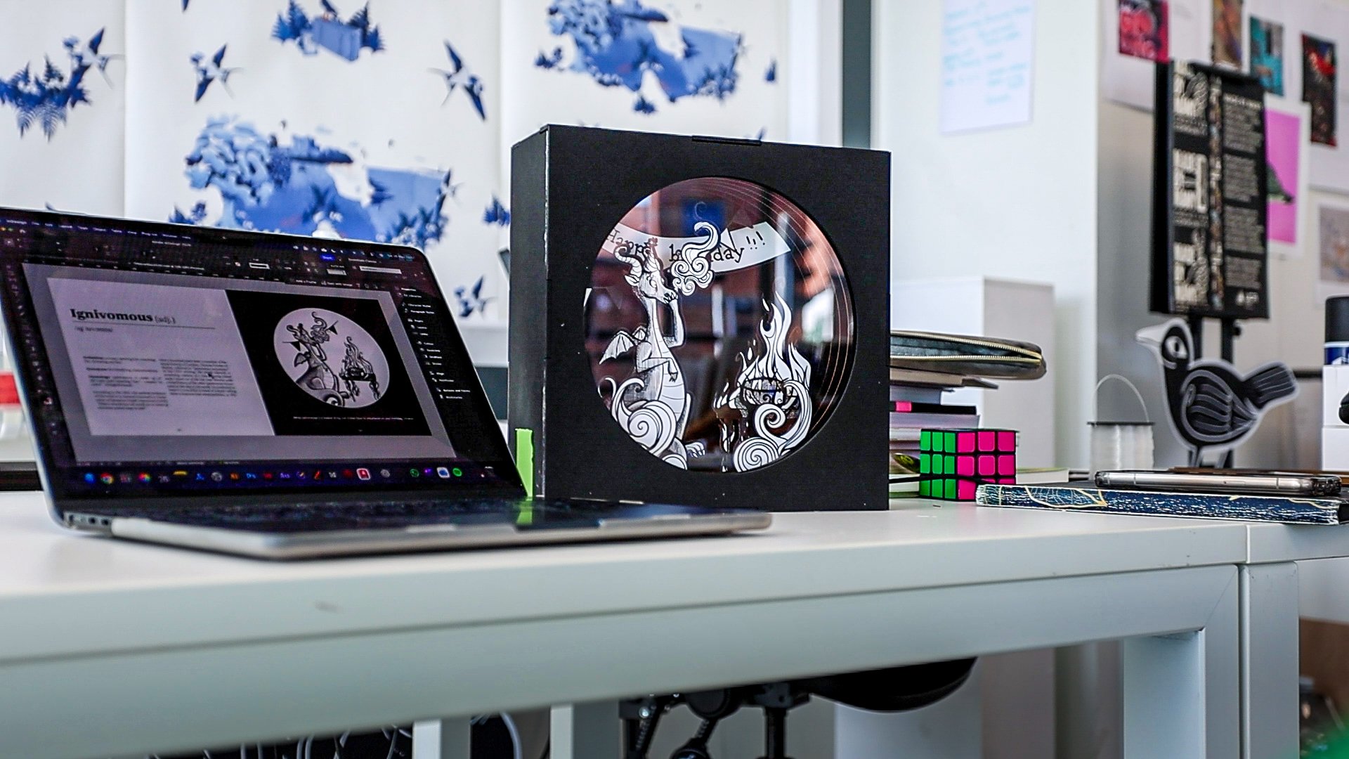 Obscurities Overheard preparatory phase showing the ignivomous illustration on a laptop next to the assembled tunnel book version.