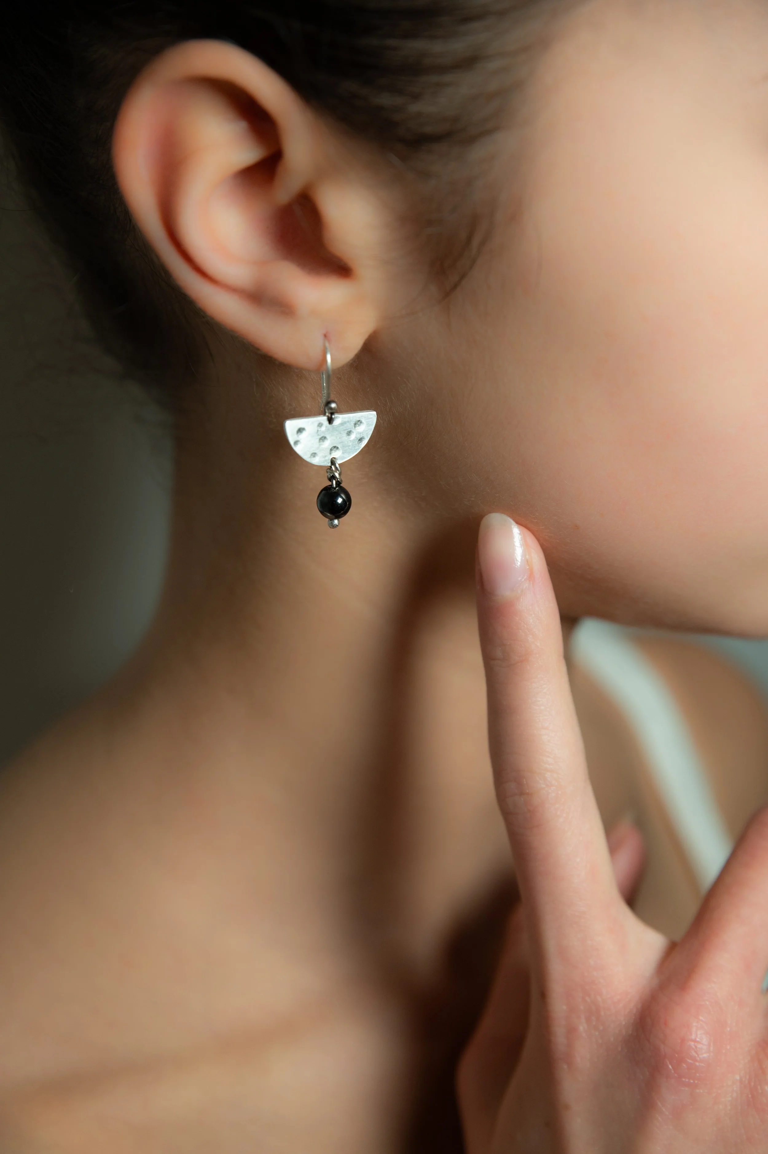 Silver "Pomona" earrings, hammer-textured semicircle discs with hematite bead