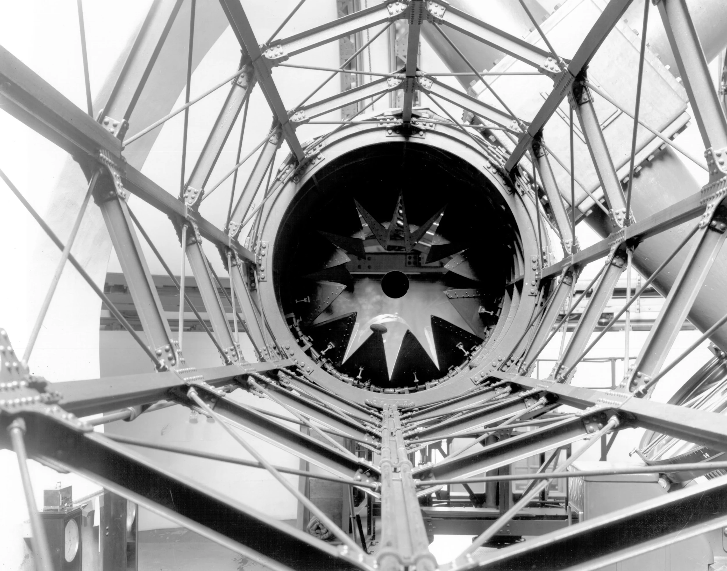 Looking up at the interior of a Ferris wheel with metal framework and support beams.