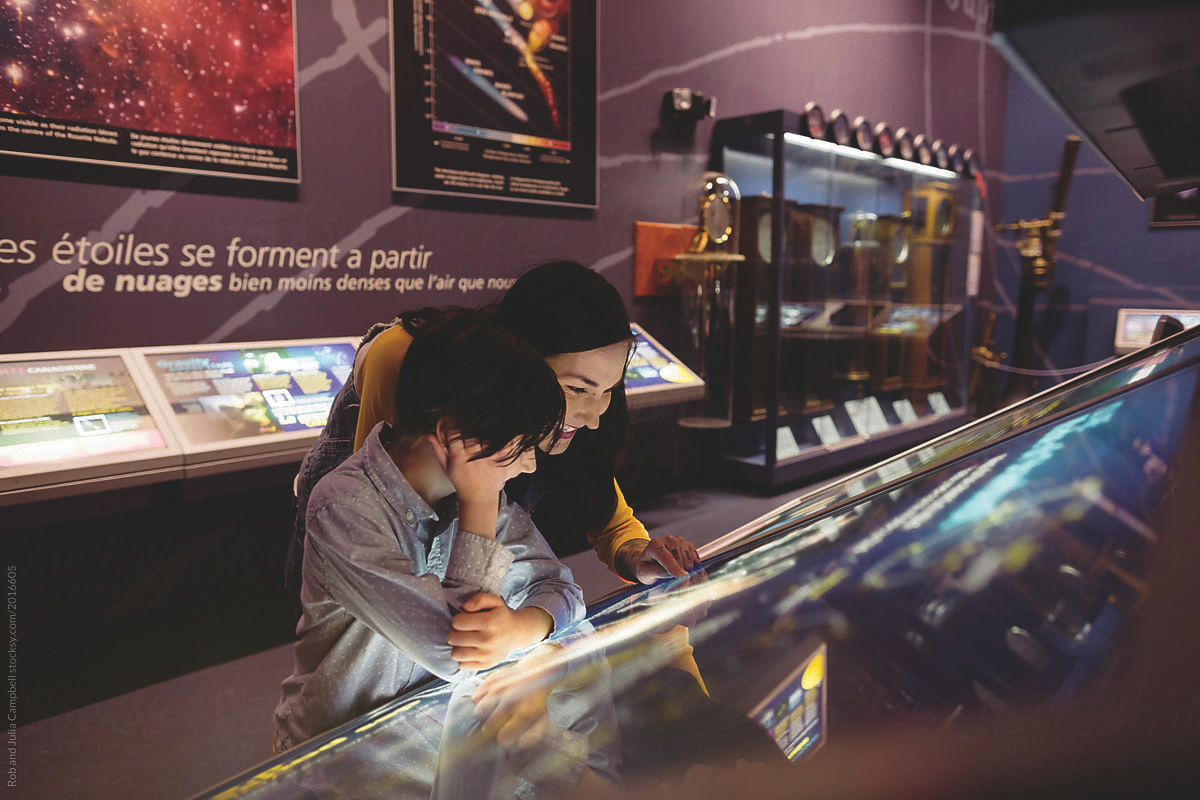 A woman and a young boy looking at an interactive display in a science museum.