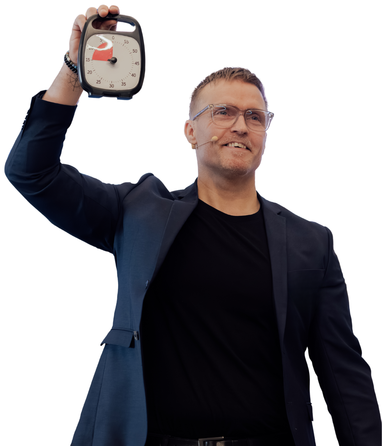 Mand med briller og mikrofon, holder et stopur, smilende under en præsentation.