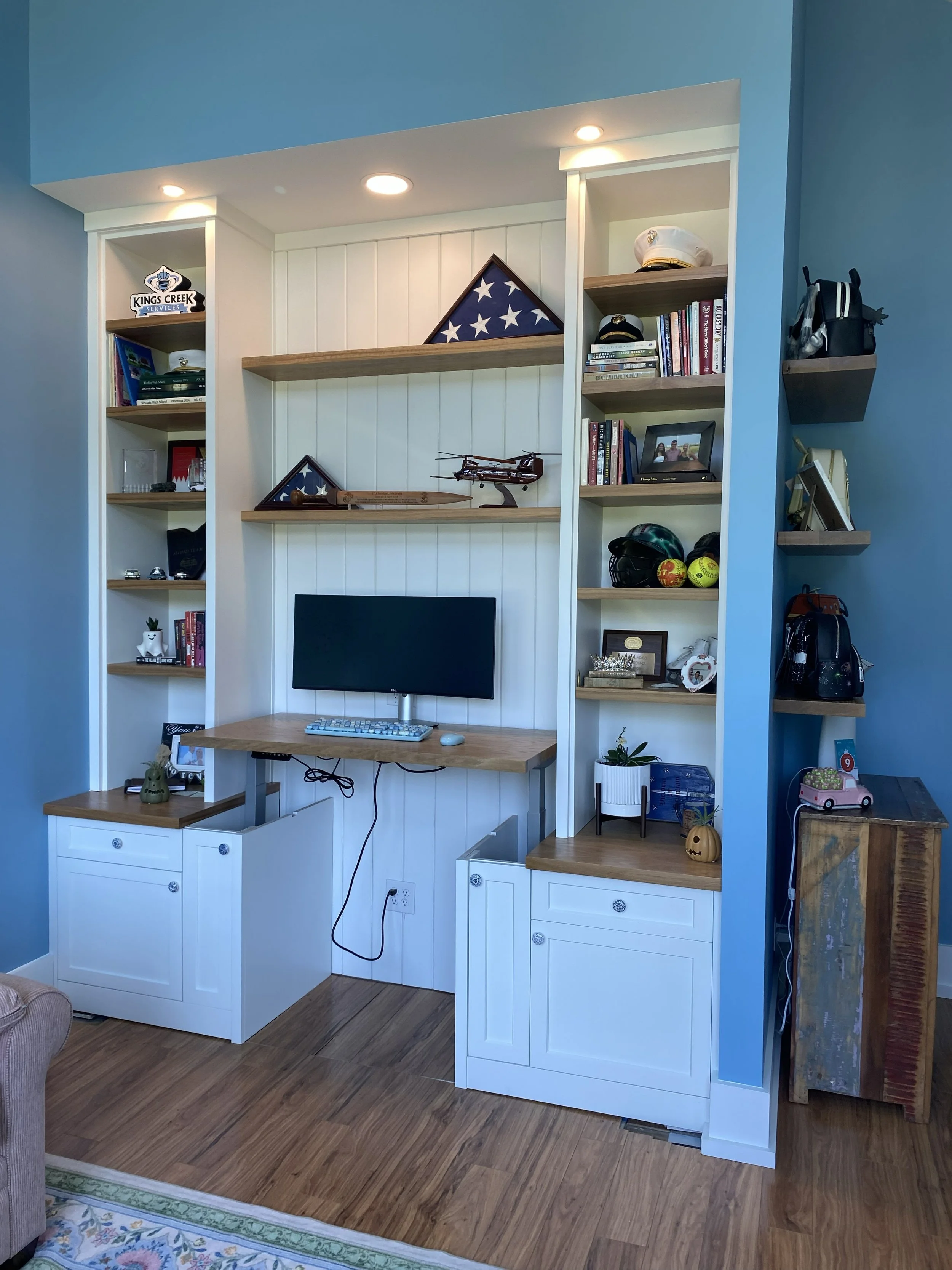 Custom office built-ins with lighted bookcase shelves, desk and drawers in Wilmington, NC