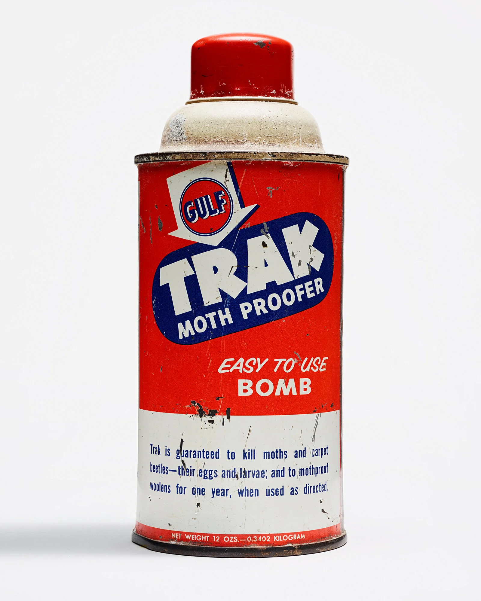Red vintage can of Gulf Trail Moth Proof, labeled as easy to use bomb for killing moths, carpet beetles, eggs, and larvae, with some wear and tear.
