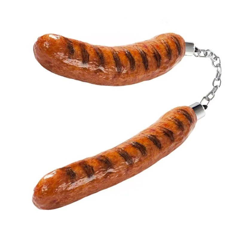 A keychain in the shape of two grilled sausages with grill marks.