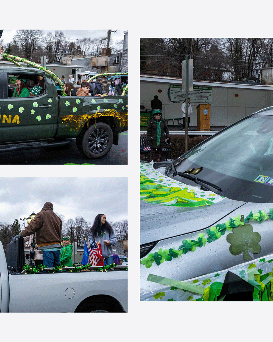 Parade float decorated with green shamrocks and ribbons for St. Patrick's Day, with people dressed in green and a crowd along the street.