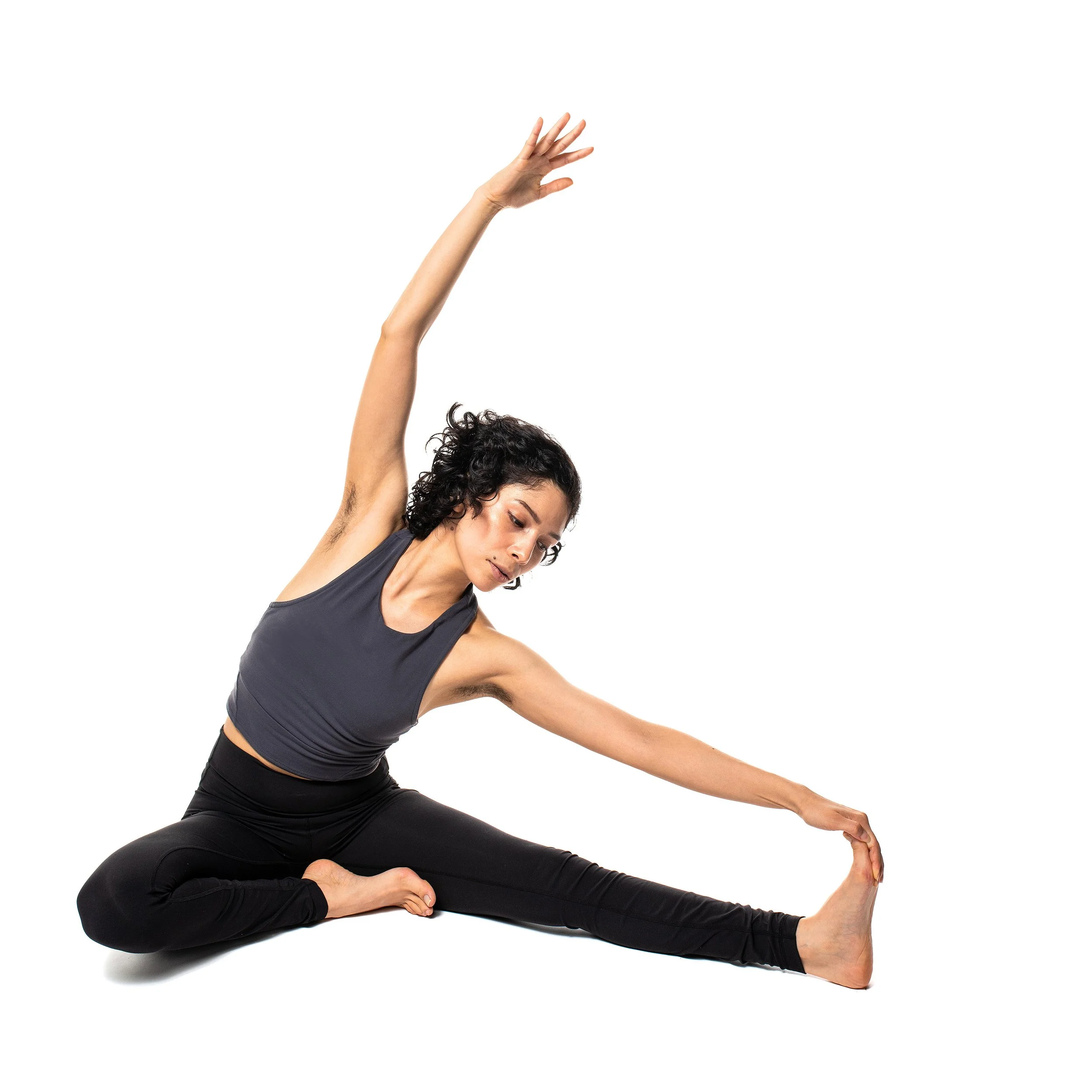 Woman practicing yoga in seated side stretch pose on white background