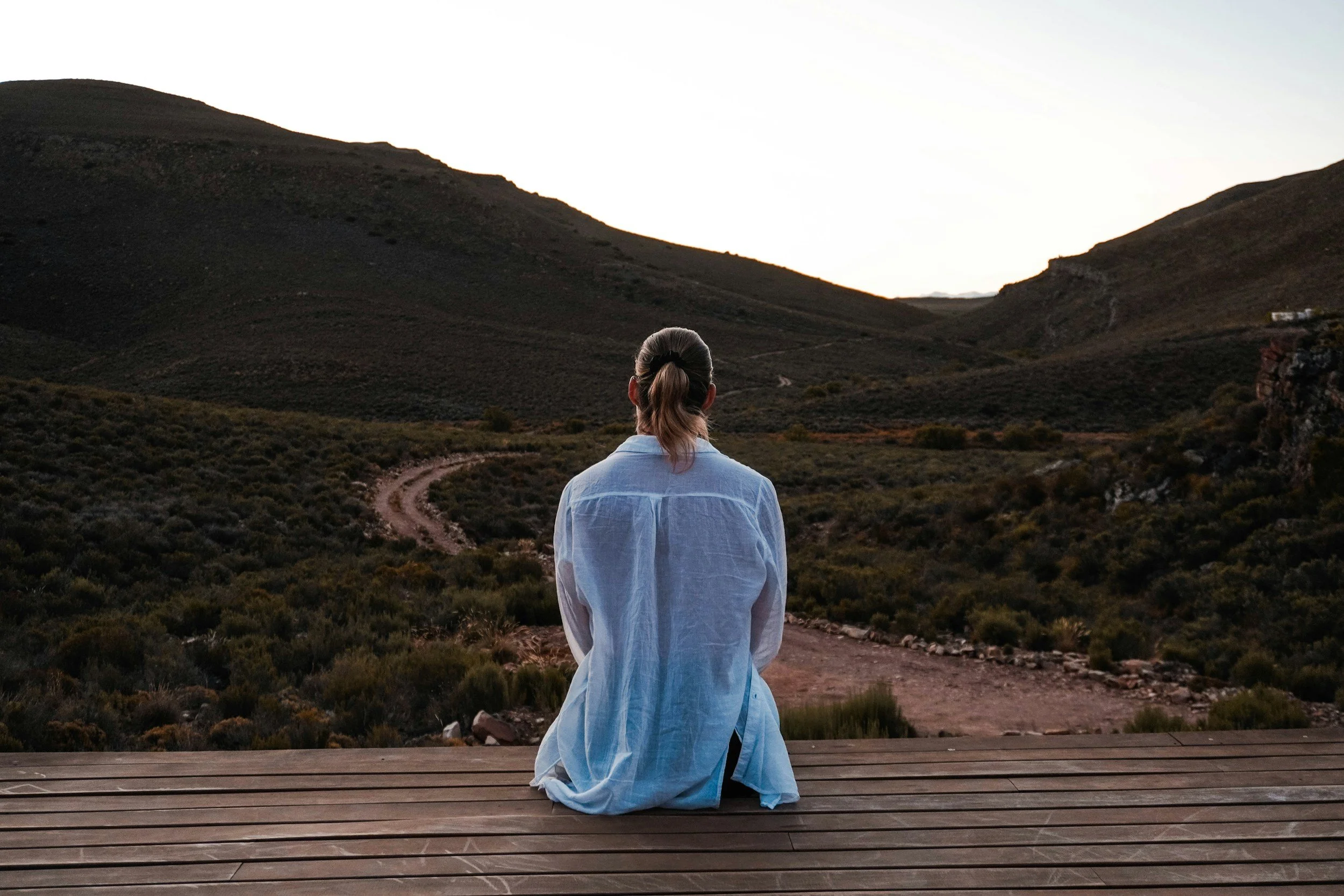 A person meditating in nature with a peaceful expression, symbolizing healing and self-discovery