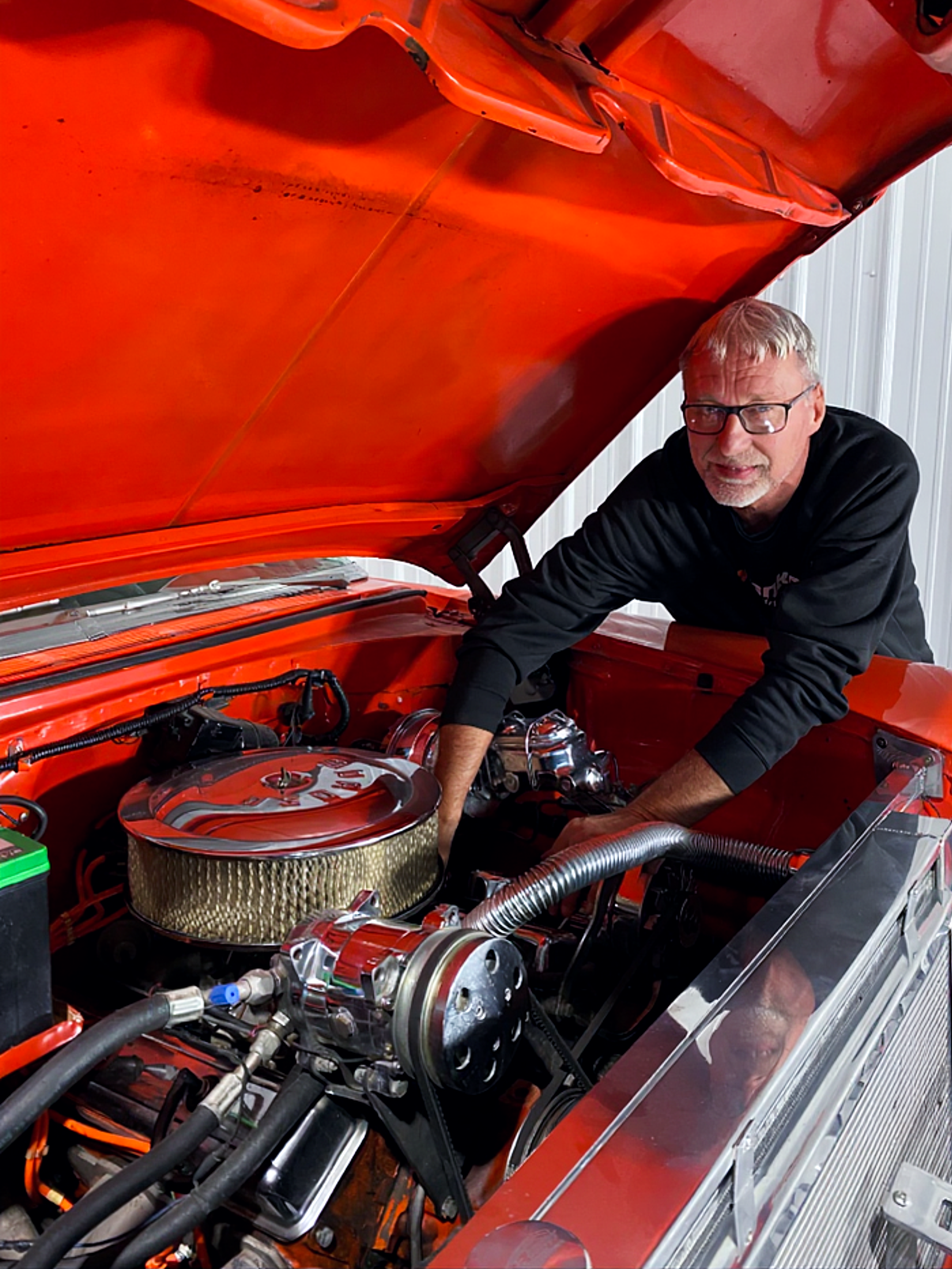 Jeff Van Sant owner of Van Sant Classic Garage working under the hood of a classic car.