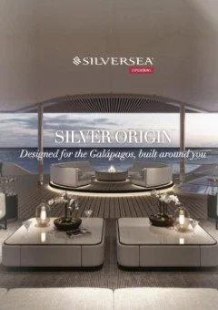 Interior view of a luxurious yacht with a central seating area, surrounded by large windows overlooking the ocean, displaying the Silver Sea Silver Origin branding.