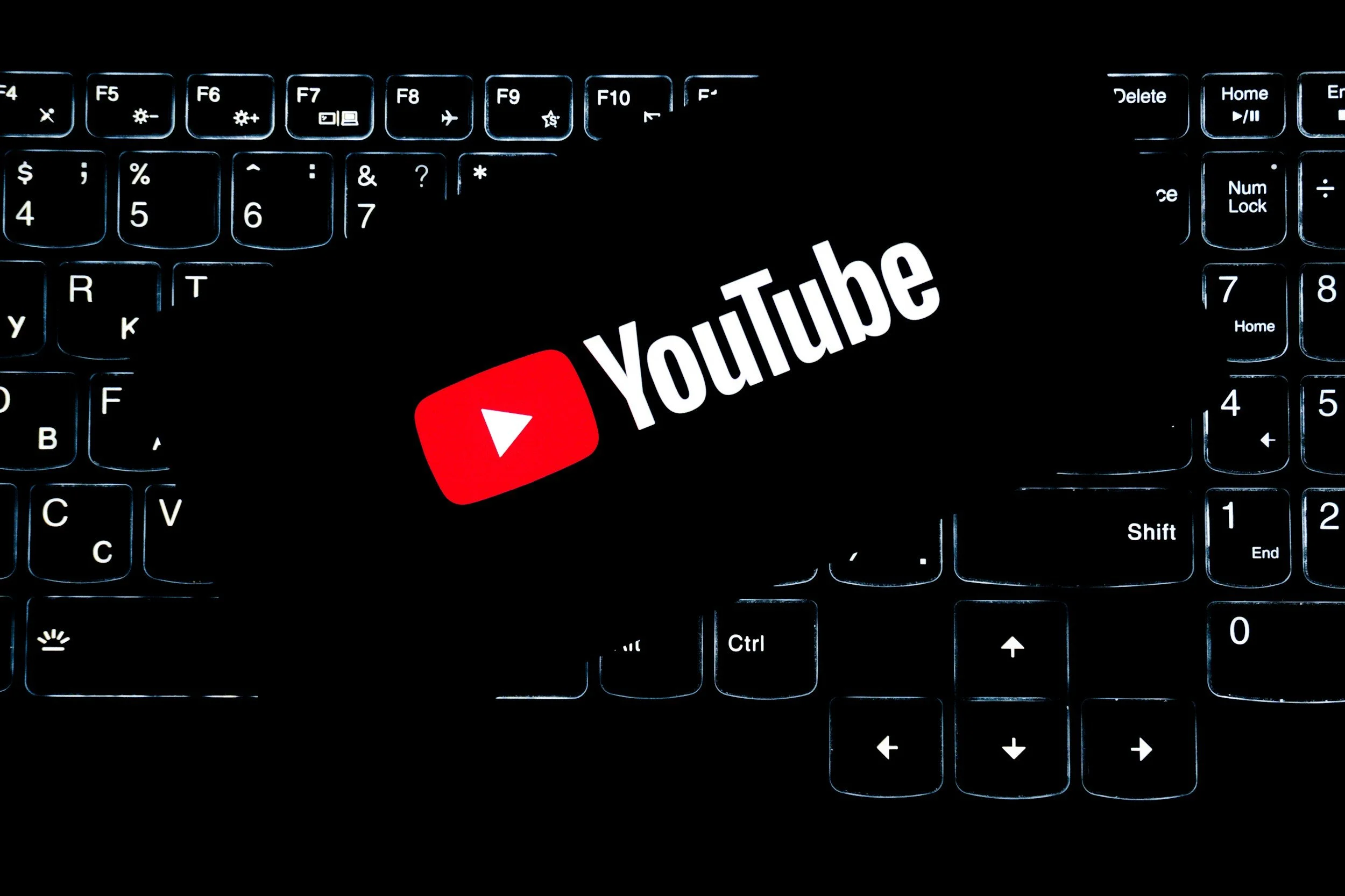 Backlit computer keyboard with YouTube logo and text on the trackpad.