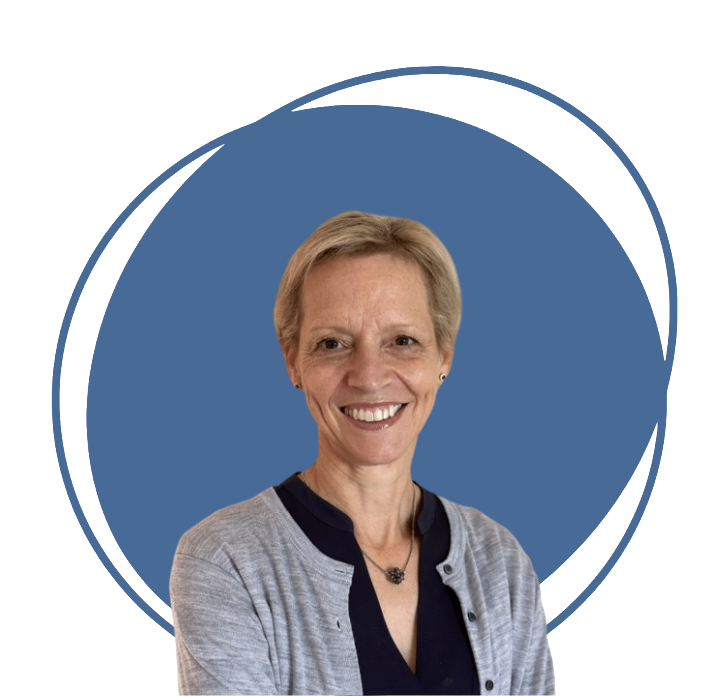 Une femme souriante avec des cheveux courts, portant un chandail gris et un collier, contre un fond bleu.