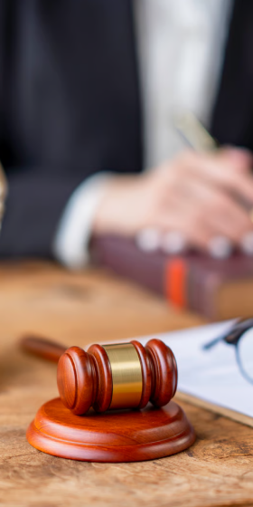 Gavel and sound block on a wooden table in a legal setting.