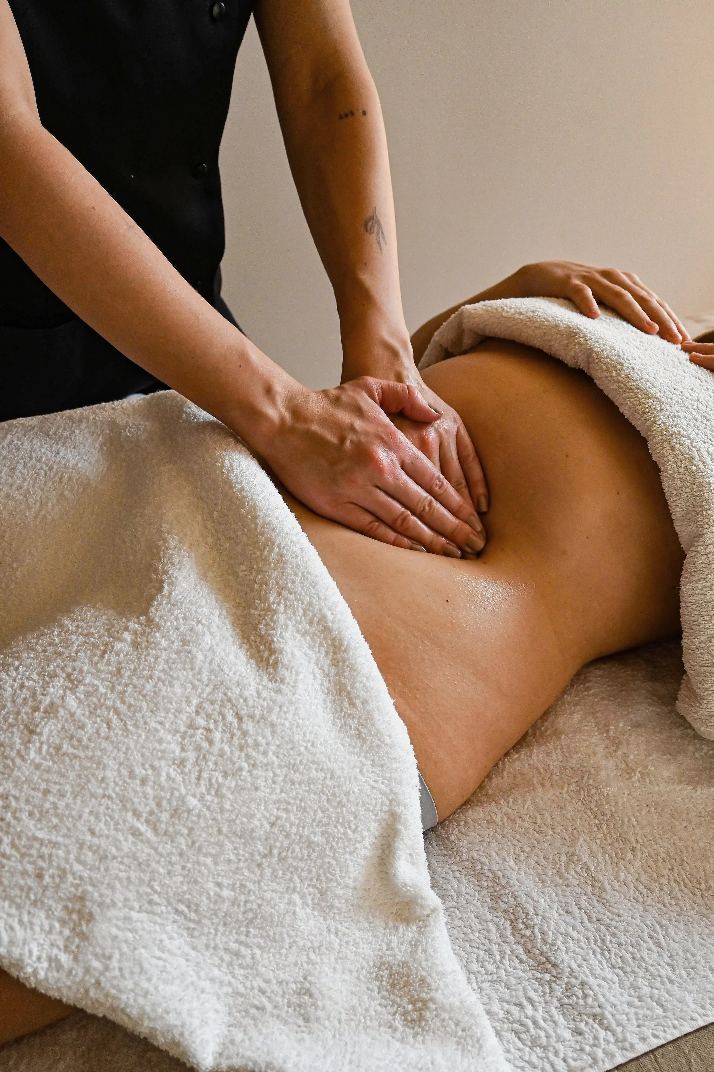 Mains du thérapeut sur le ventre du client pour traitement de drainage lymphatique méthode Renata França du ventre pour amincement