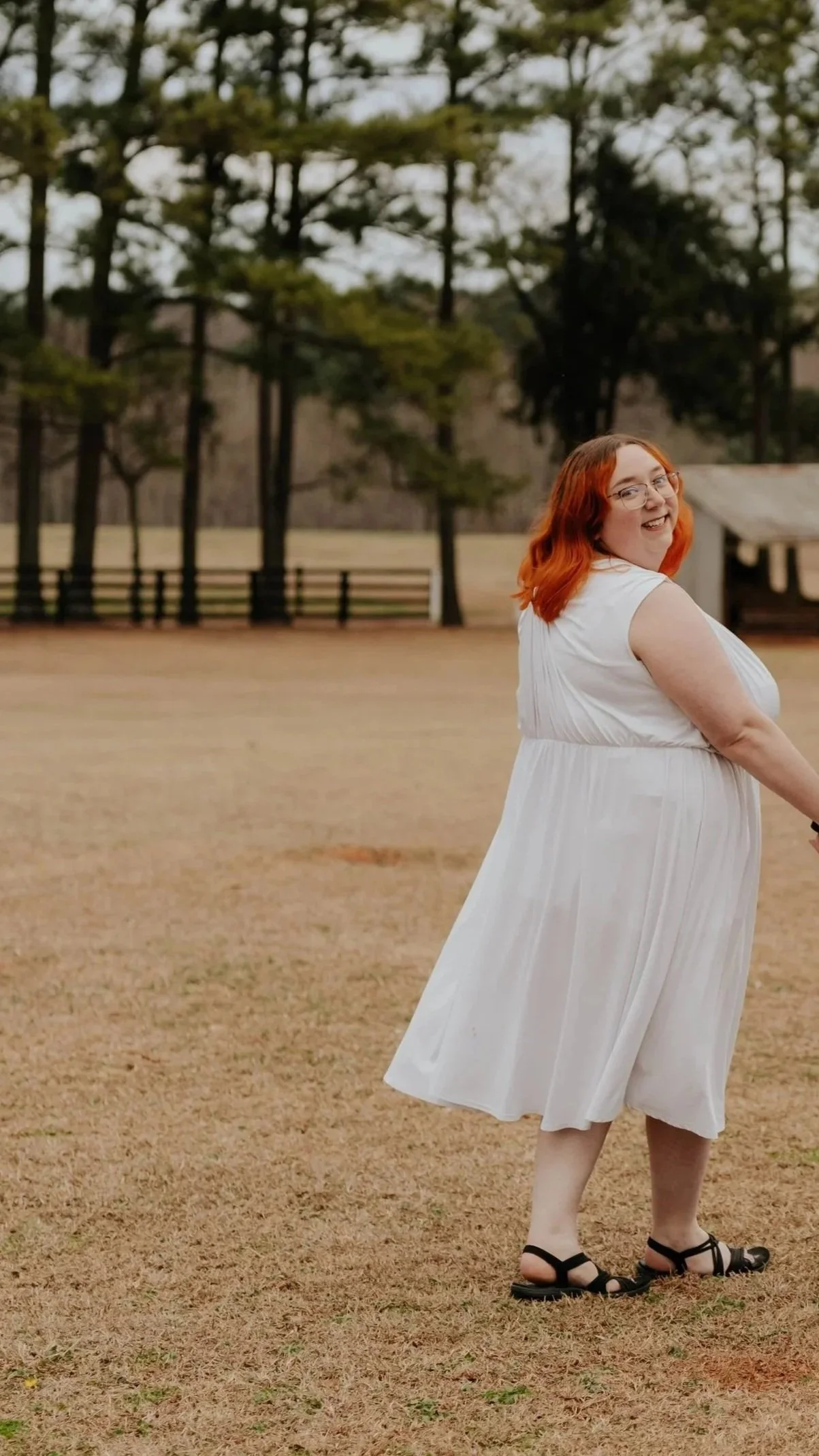 Brittany with a white dress looking over her shoulder and smiling