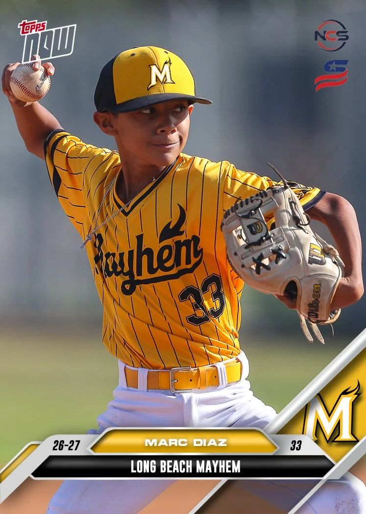 Young boy smiling, wearing a black and yellow baseball uniform and cap, holding a baseball bat, standing against a plain background.