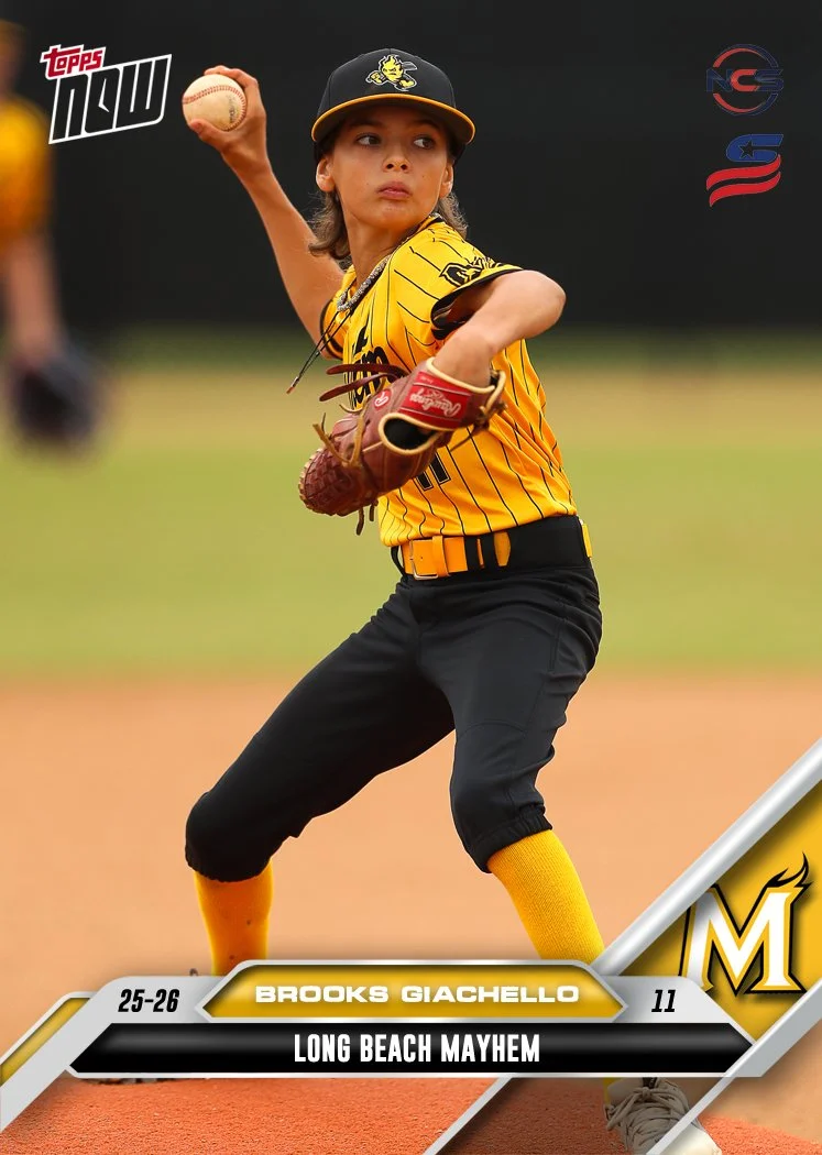 Young boy smiling, wearing a yellow baseball jersey with black pinstripes, a black and yellow cap tilted to the side, and a baseball belt.