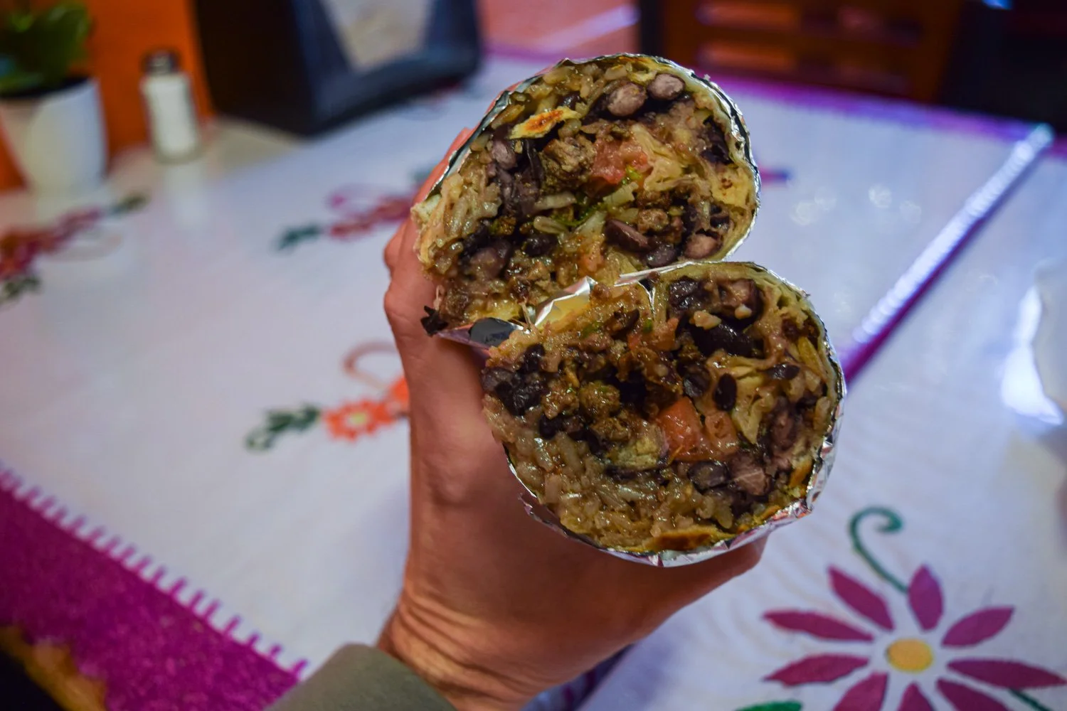 Close-up of a cut carne asada burrito from La Oaxaqueña, showing the browned tortilla and balanced fillings.