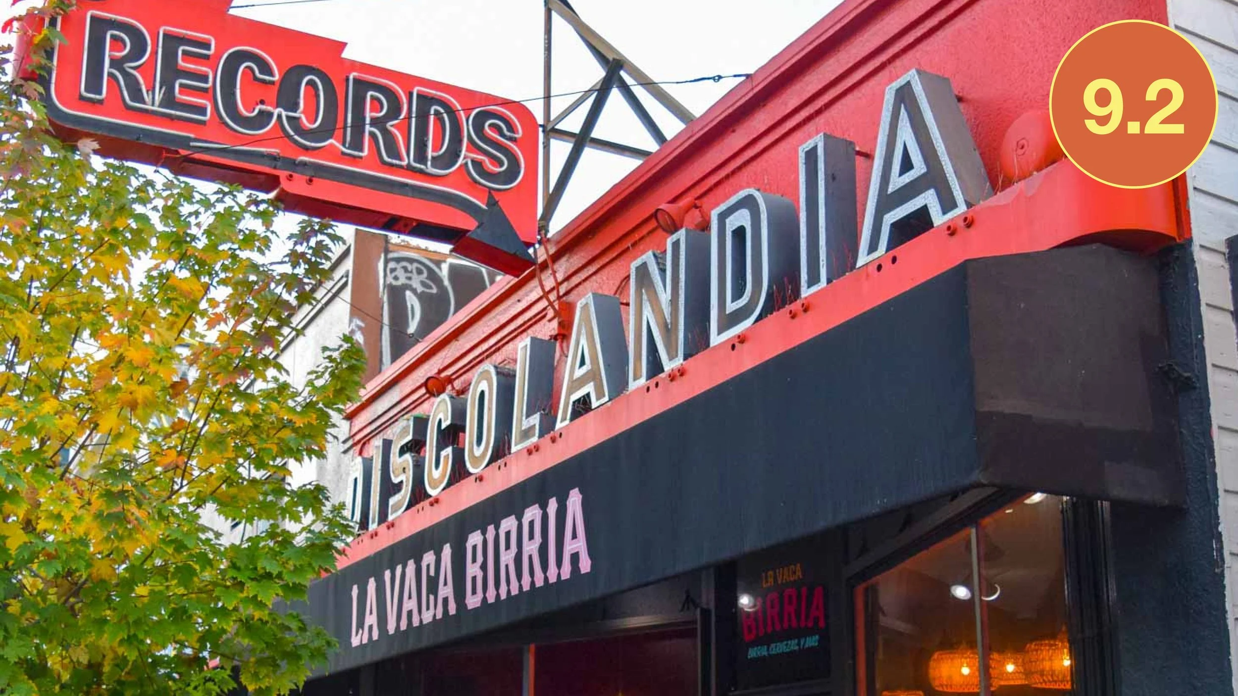 The exterior storefront of La Vaca Birria in San Francisco, located within the historic Discolandia building. The image shows a large red "RECORDS DISCOLANDIA" vintage sign with the restaurant's name on the black awning below.