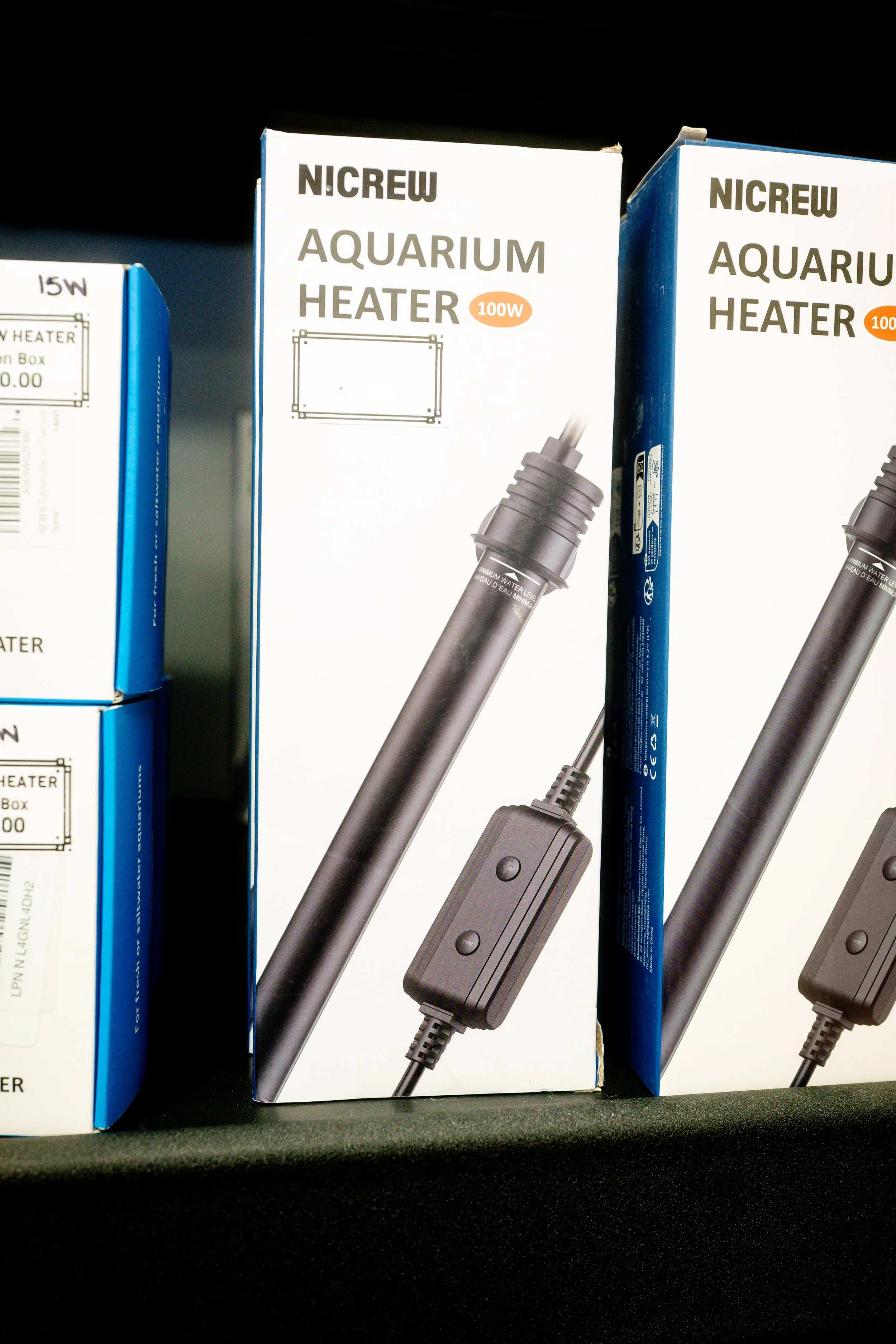 Boxes of NICREW Aquarium Heaters, 100W, black, displayed on a store shelf.