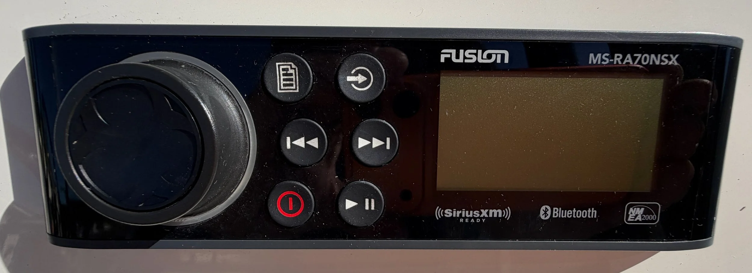 A black Fusion MS-RA70NSX marine audio system with a digital display, control buttons, and Bluetooth and SiriusXM logos.