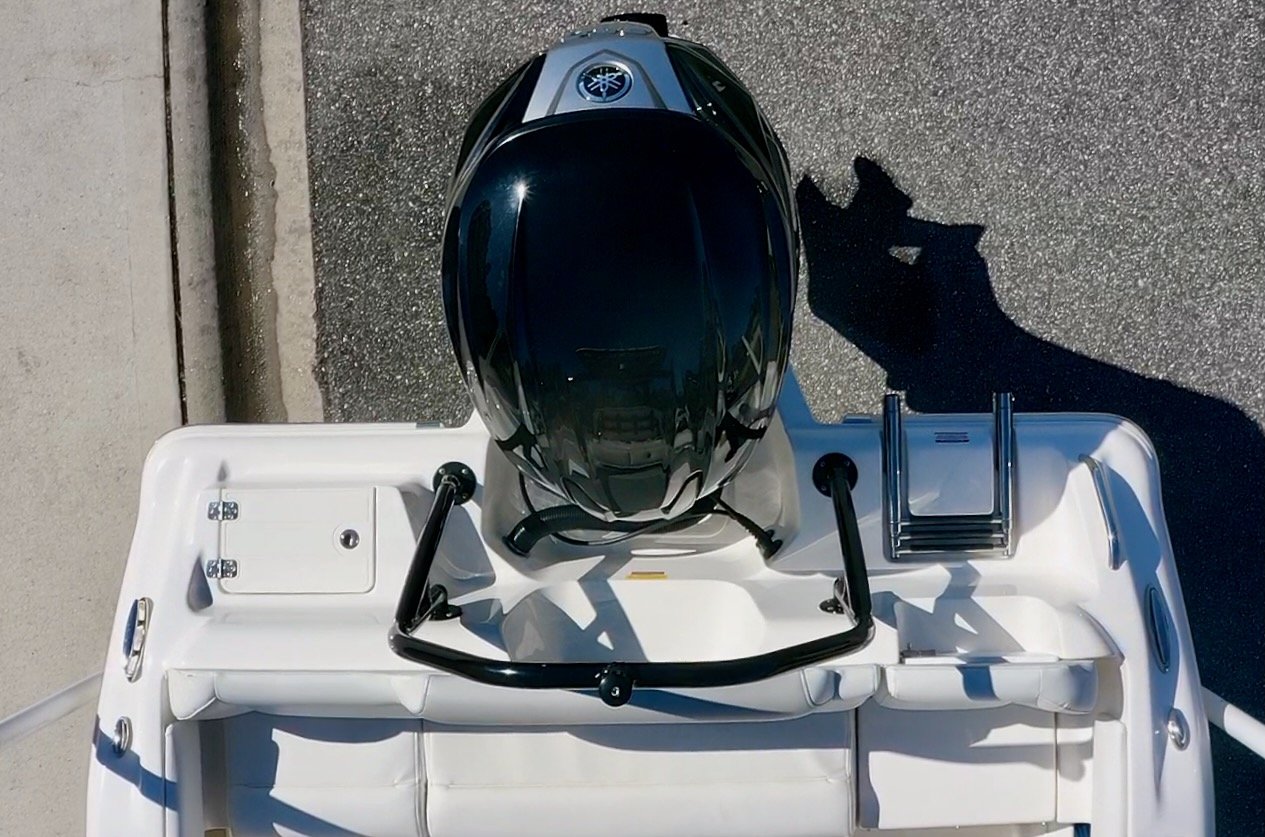 Overhead view of a black and silver motorboat with a Yamaha outboard engine, parked on pavement.