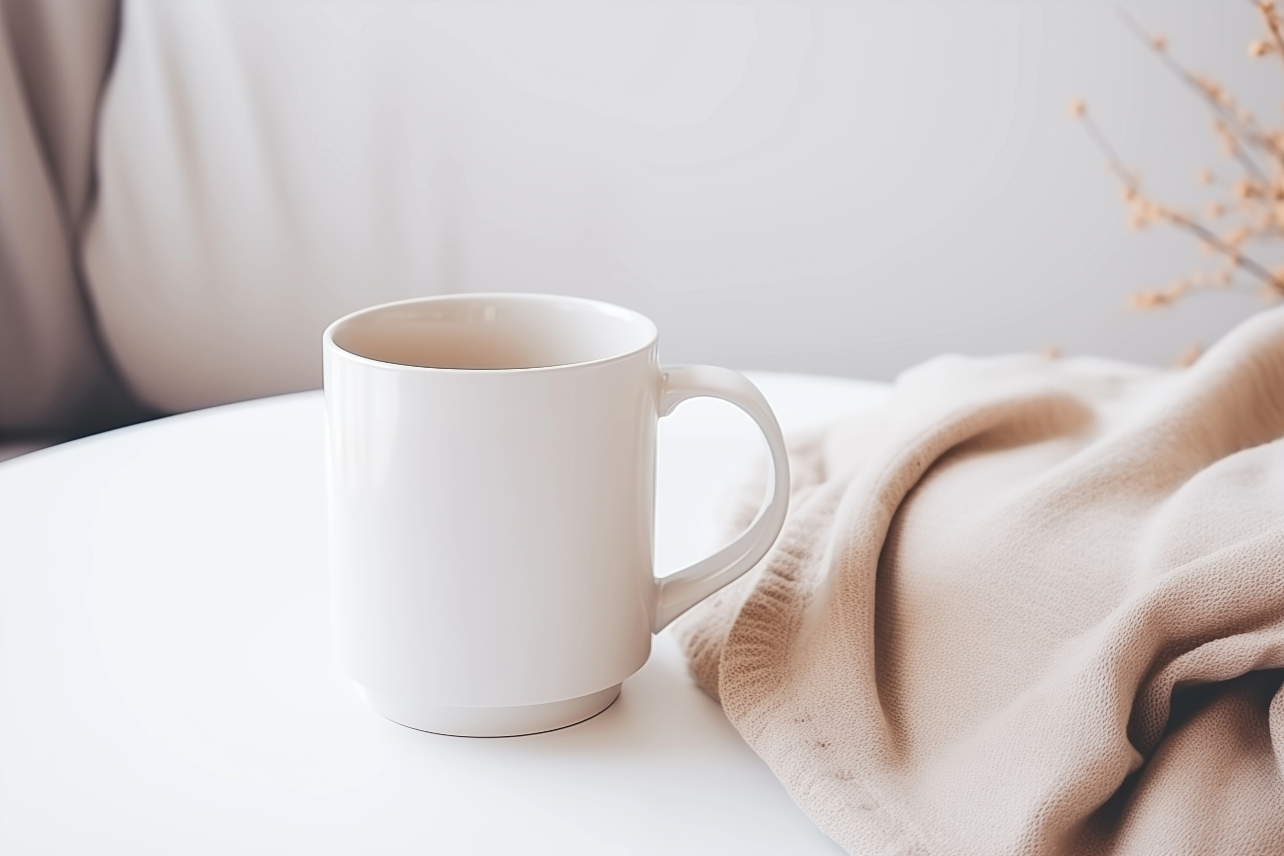 A white coffee mug placed on a white surface next to a beige fabric with soft lighting.