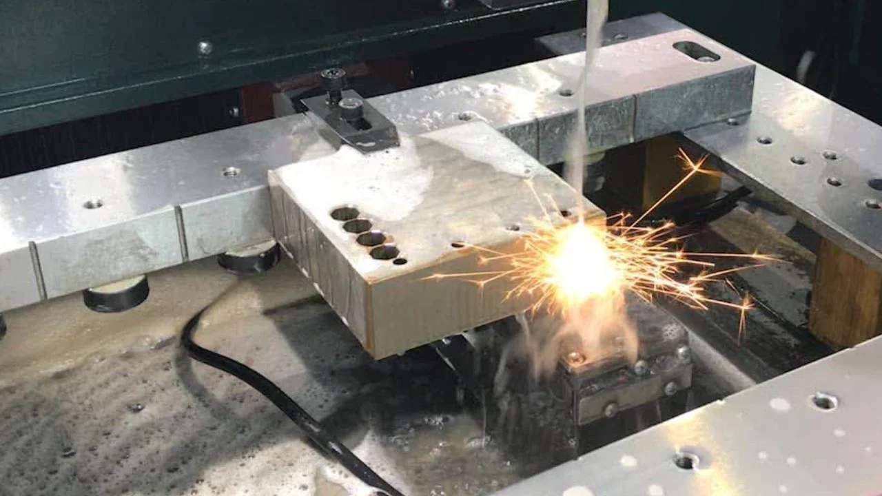 Metalworking machine welding or cutting metal, sparks flying from the process.