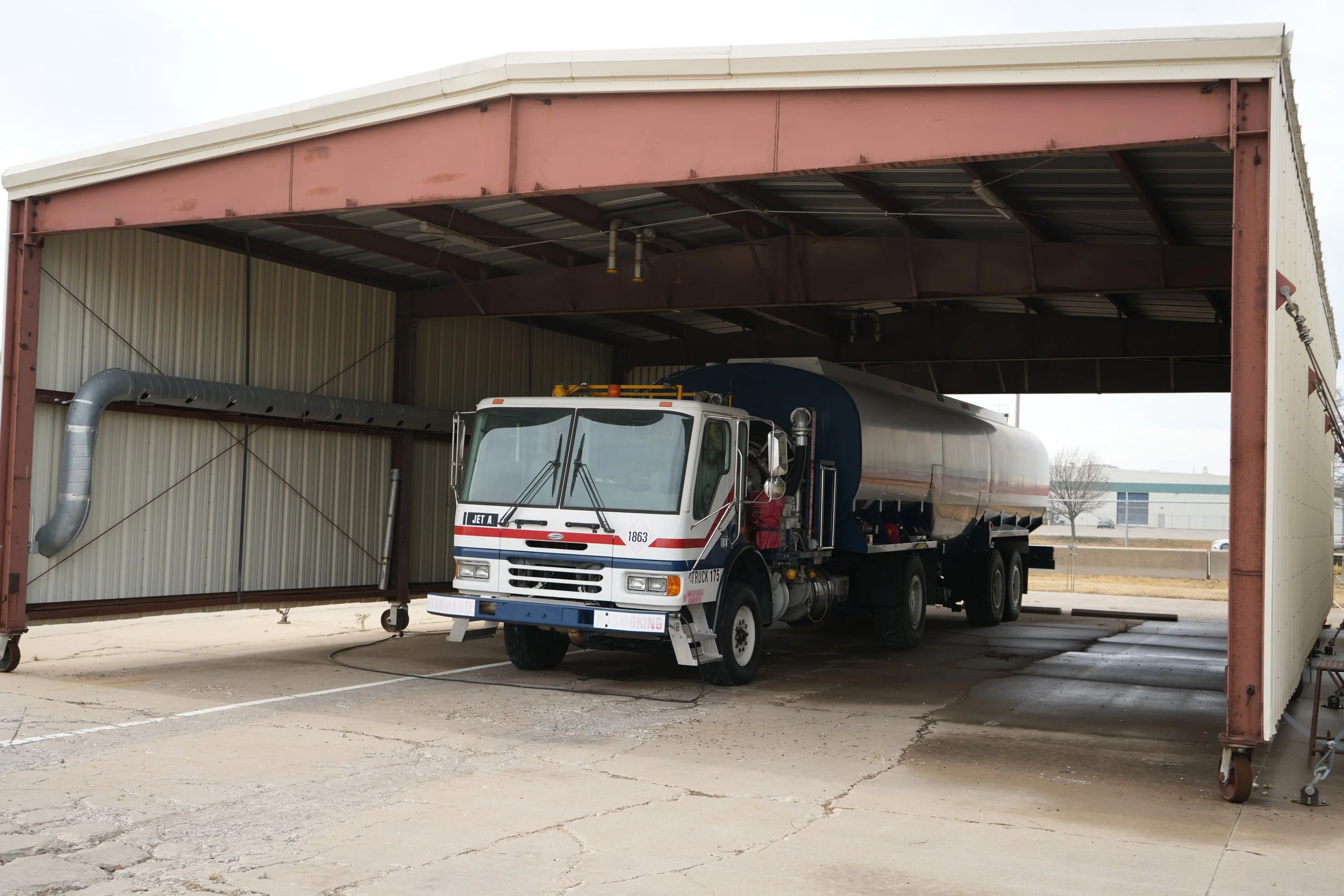 A tanker truck parked inside an industrial garage.