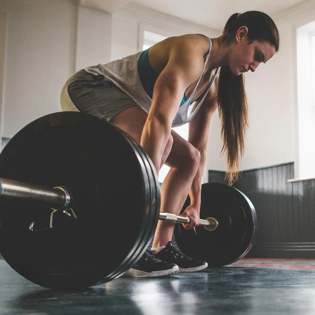 Mujer haciendo peso muerto en el gimnasio.