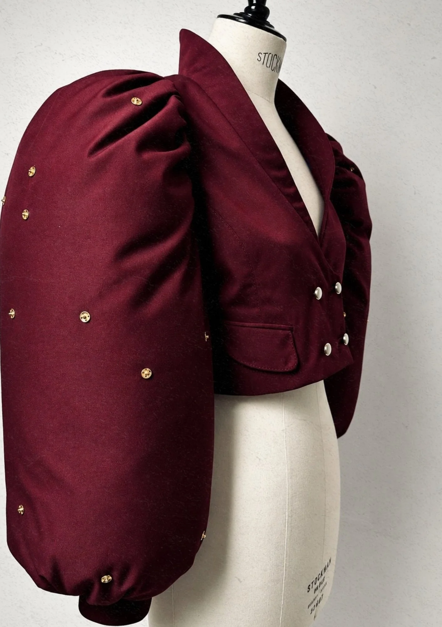 Burgundy balloon sleeve of the Gaïa suit on a dress form, before the ornaments are added.