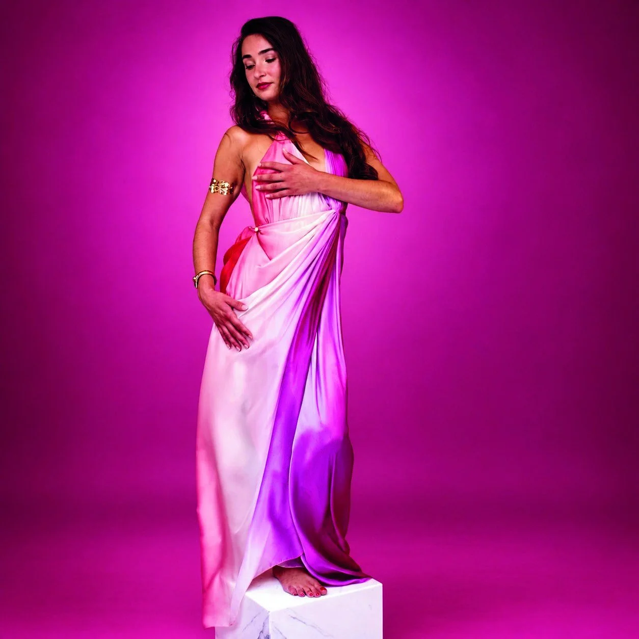 04 — APHRODITE · Le désir
Une soie aux couleurs du couchant se drape autour du corps. Les plis convergent à la taille et libèrent le mouvement de la jupe.
