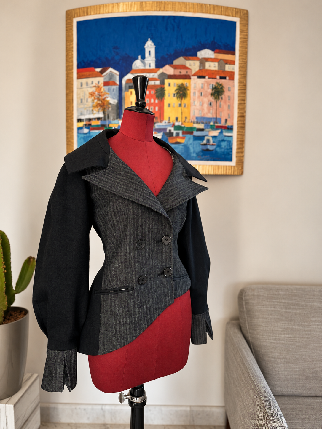 Veste de tailleur croisée en patchwork gris et noir, à taille dessinée, présentée sur mannequin.