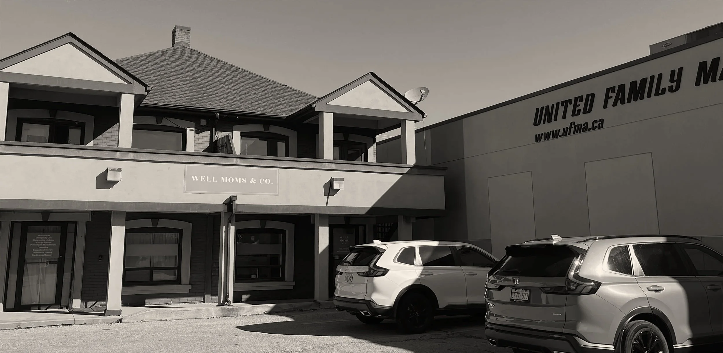 a parking lot shared by Well Moms & Co and United Family Martial Arts, and the business name and signage on each building.