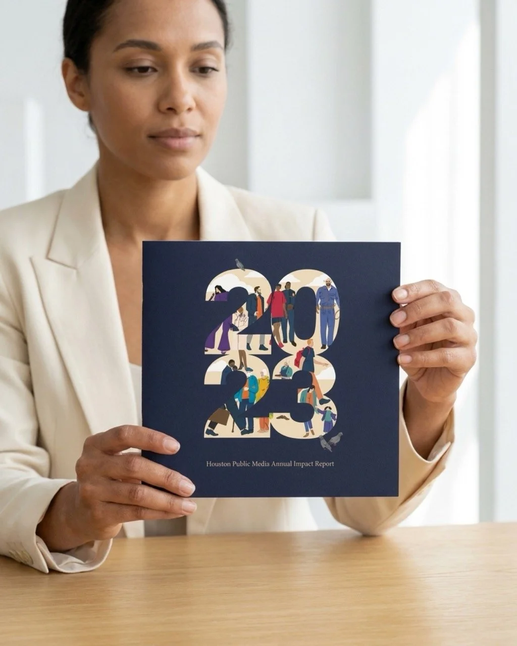 A woman holds up a copy of the 2023 Houston Public Media Annual Impact Report. The report was recognized at the Public Media Awards the following year.