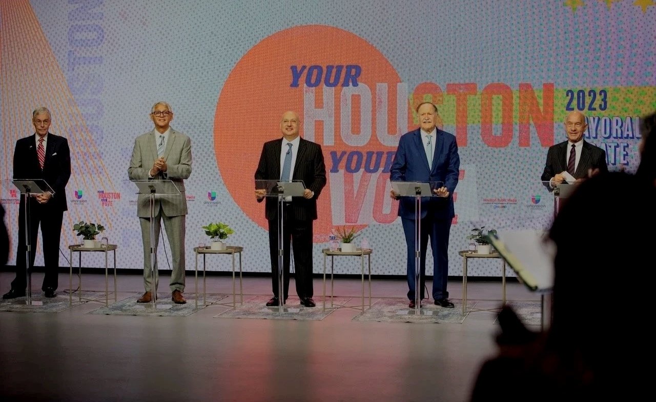 Five candidates stand at podiums on the 2023 Houston mayoral debate stage, backed by a "Your Houston, Your Vote" video wall with Houston Public Media and Univision branding.