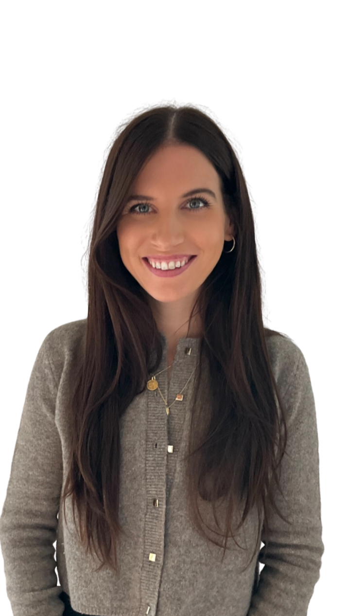 A smiling woman with long dark hair, wearing a gray cardigan and layered necklaces, facing forward.