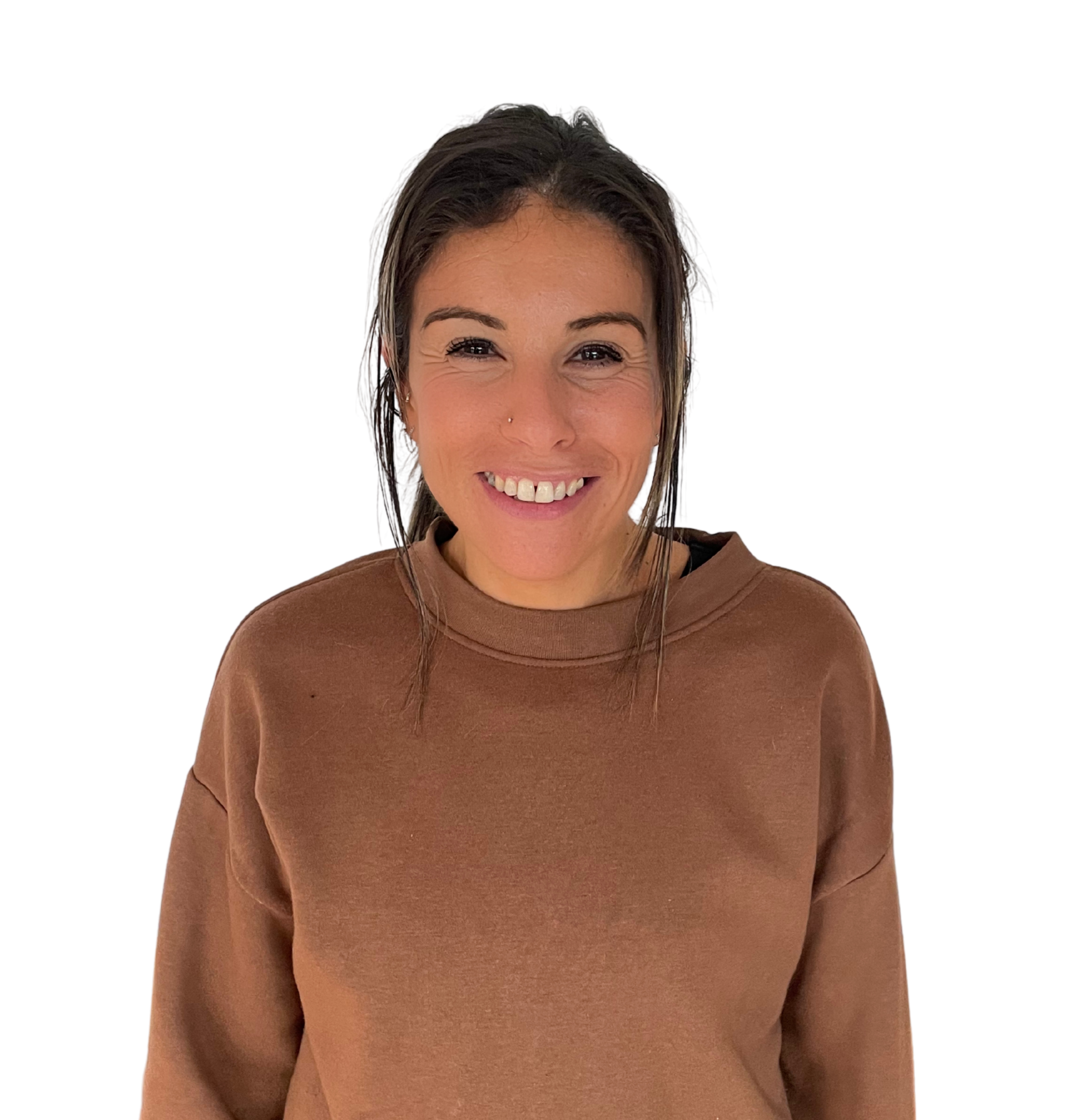 A smiling woman with dark hair, wearing a brown sweatshirt, stands against a background with color bars.