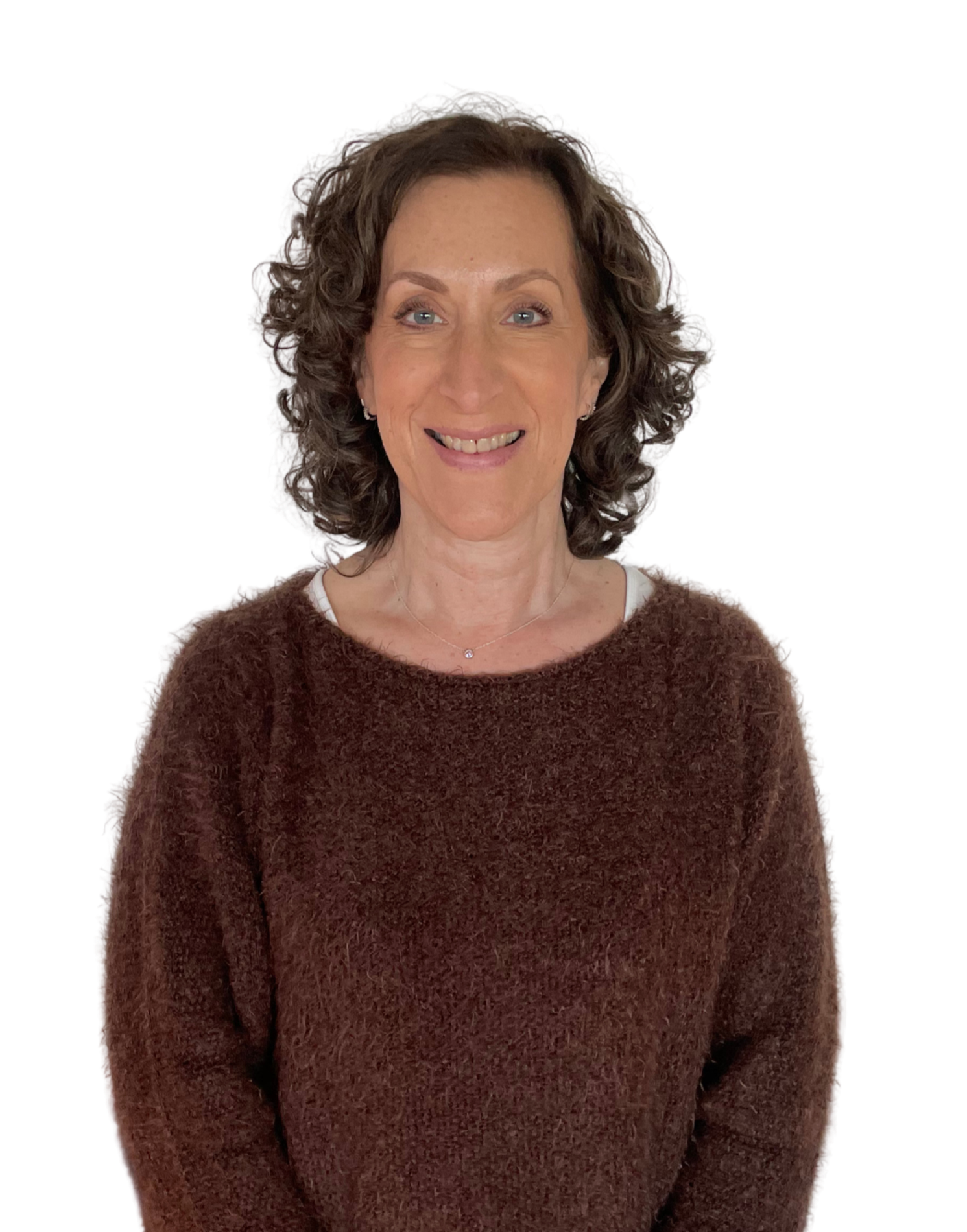 A woman with curly brown hair smiling, wearing a brown fuzzy sweater and a white shirt underneath, against a black background.