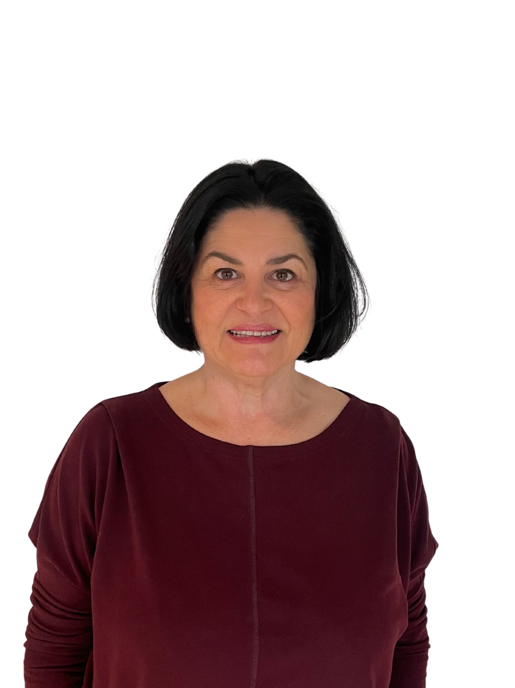 A woman with short black hair wearing a maroon long-sleeve top, smiling at the camera.