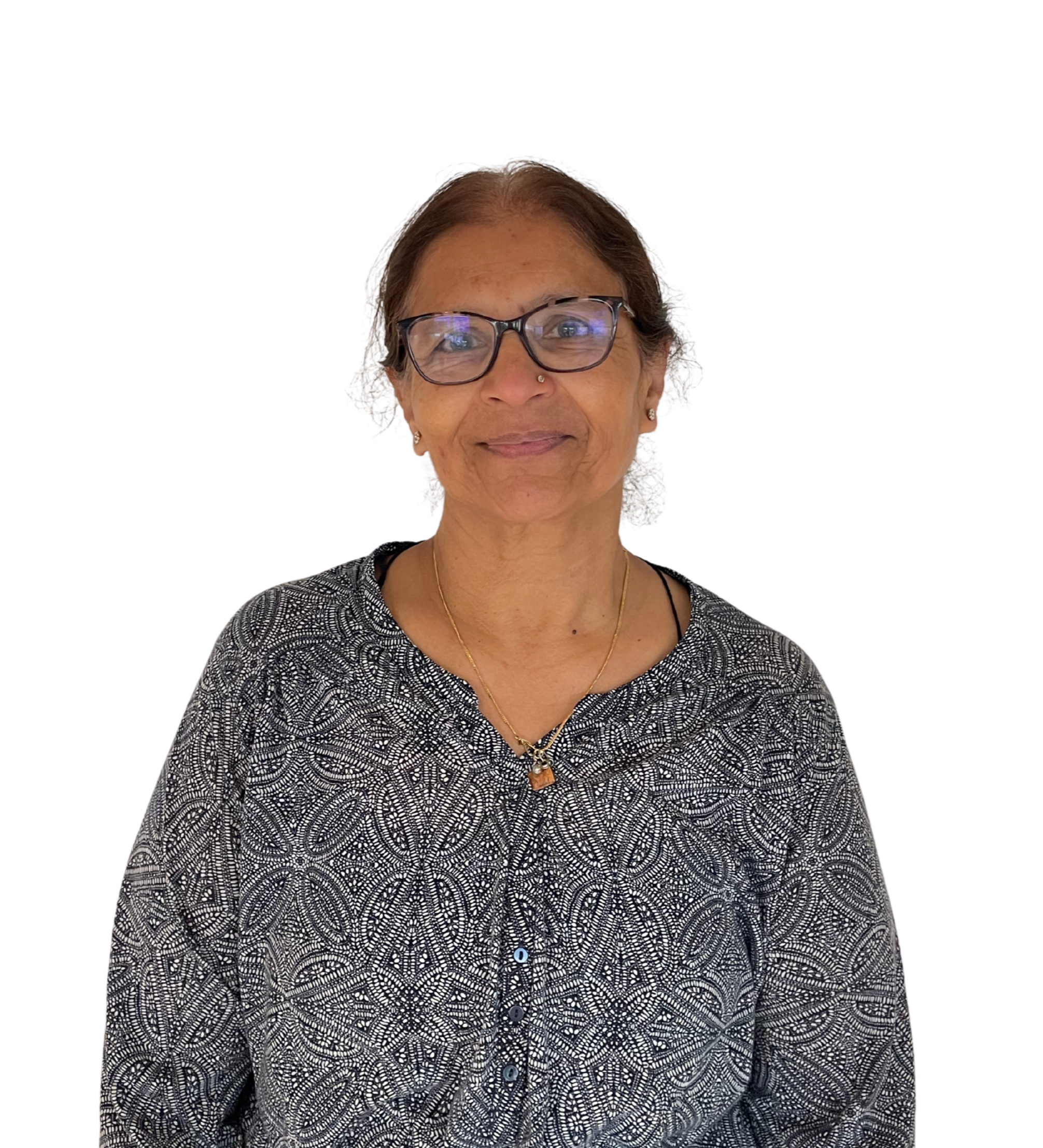 A middle-aged woman with glasses and a necklace, smiling while wearing a black and white patterned blouse.