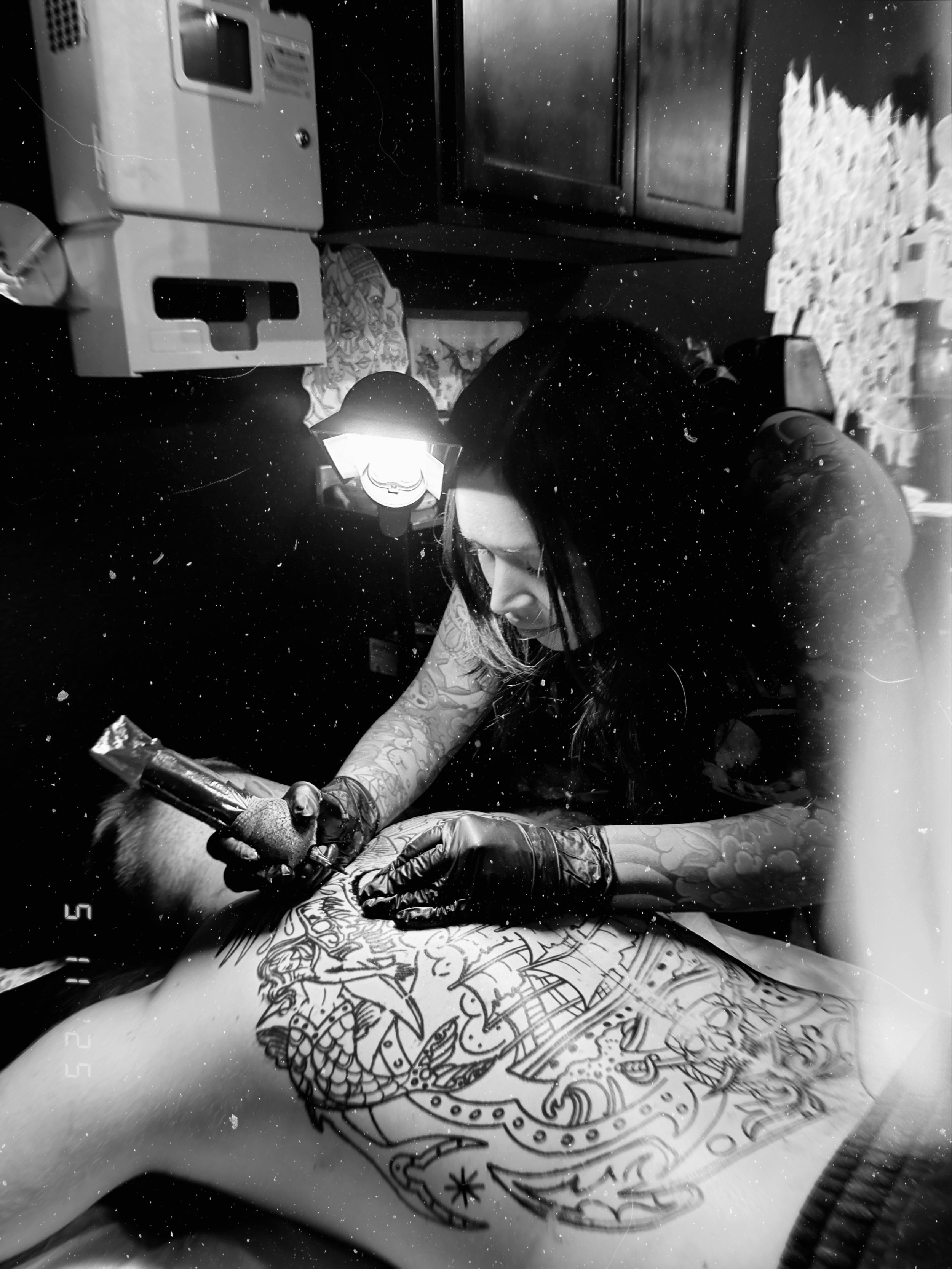 The talented and professional tattoo Artist Suzie Q is pictured tattooing a large scale American Traditional back piece on her client in Arizona.