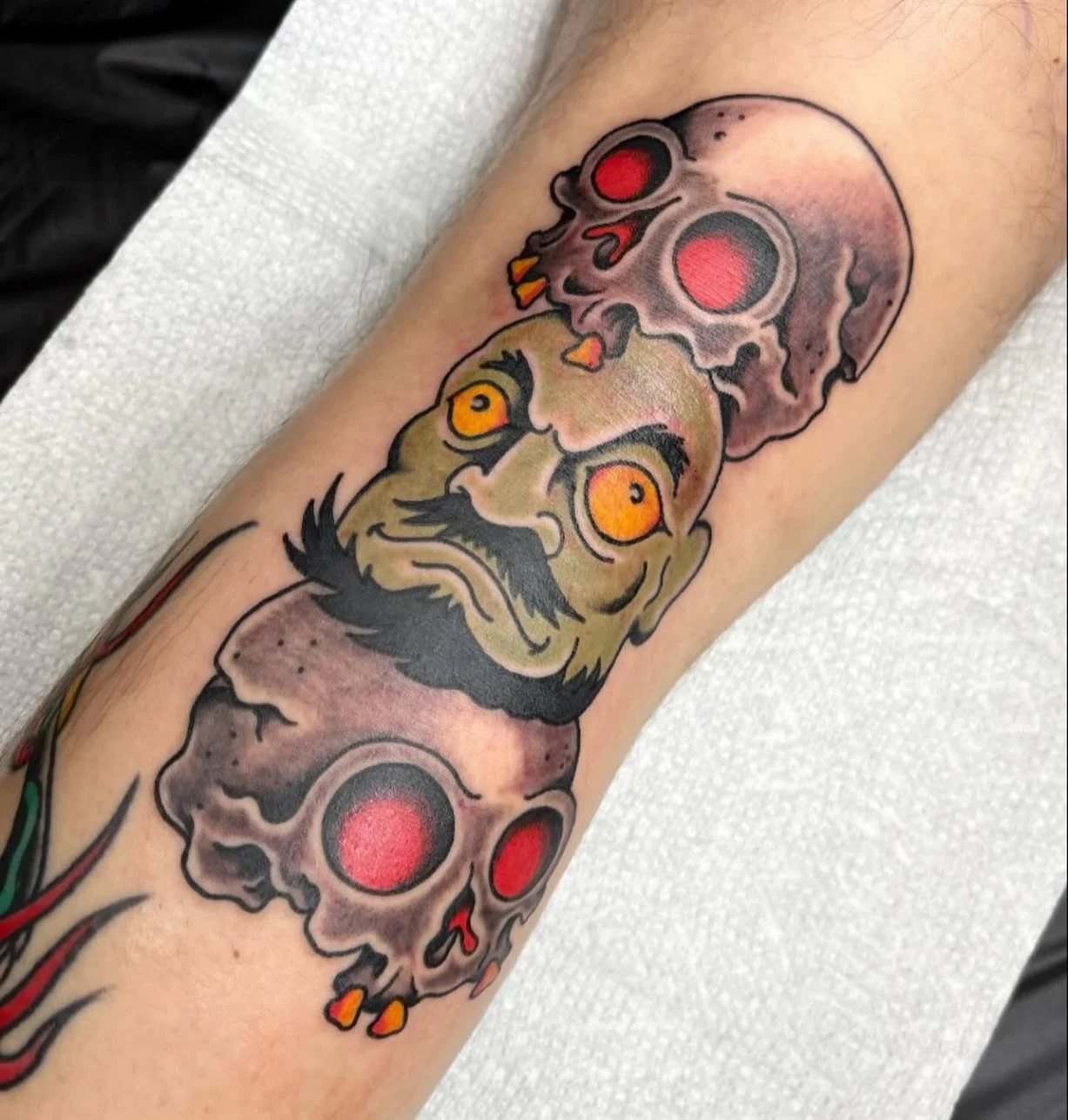 Kashira from Spirited Away, reimagined with stacked skulls and glowing eyes by @chrisnaderertattoo