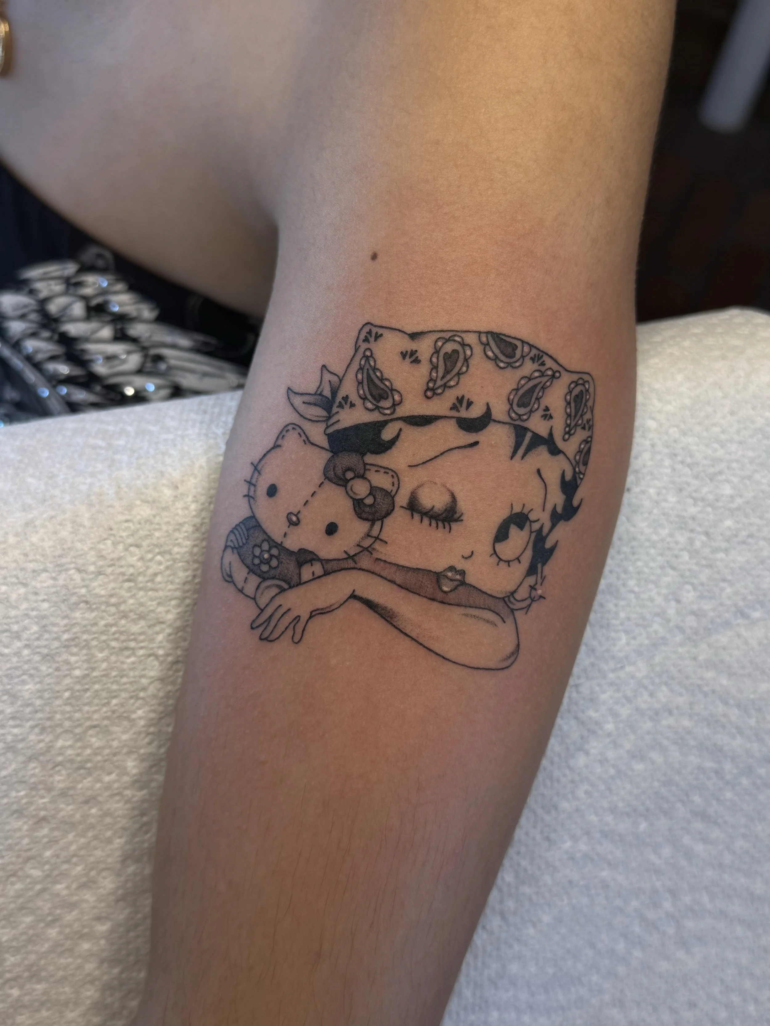 Tattoo artist Mel Gonzales, @theemelodic American Traditional black and gray Betty Boop tattoo on the arm at Dame of the West Tattoo in Scottsdale, Arizona.