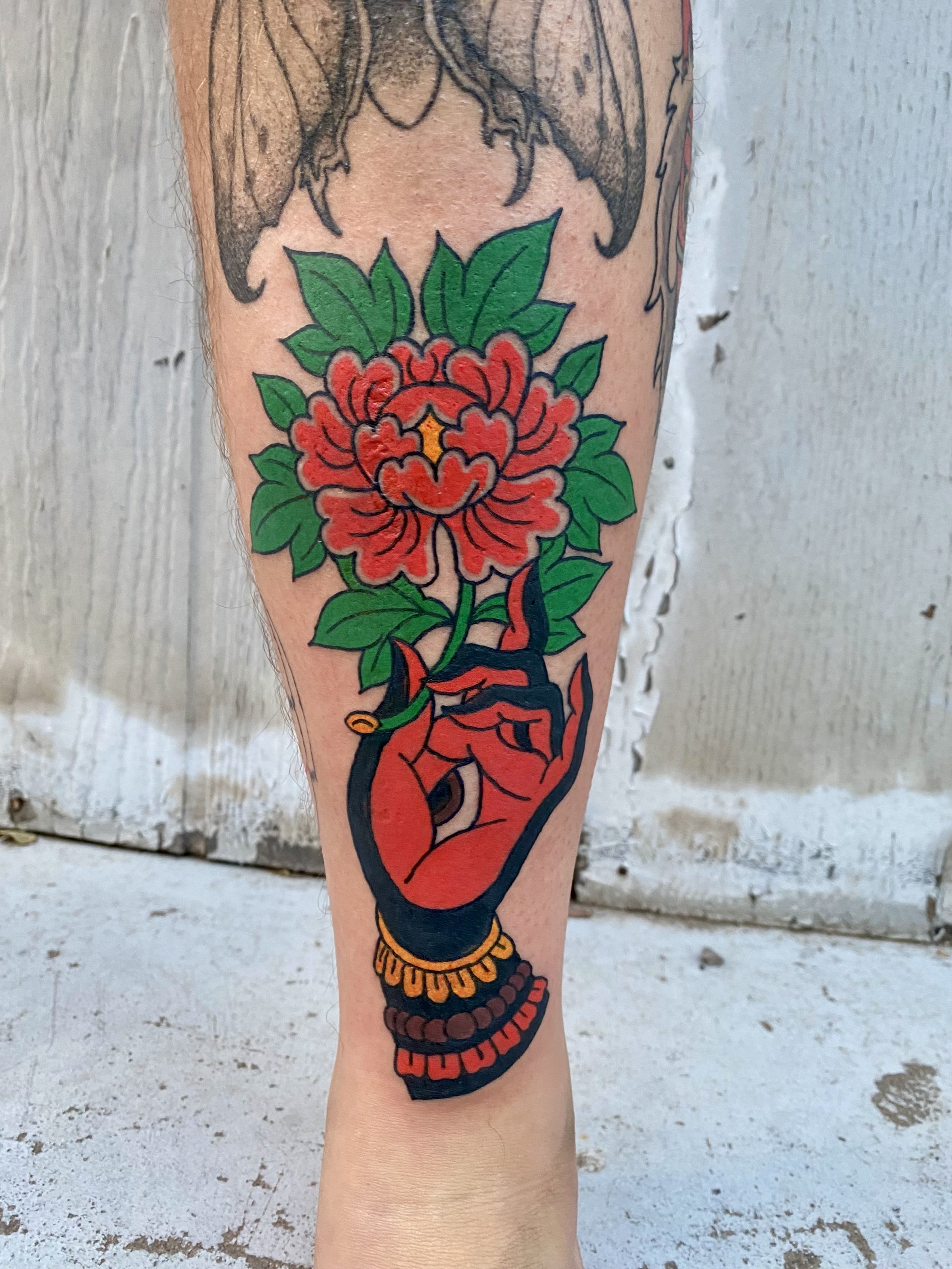 Jonas Richards, @jonasrichardstattoo Traditional Style Hand & Flower Tattoo on the shin done at Dame of the West Tattoo in Scottsdale, Arizona.