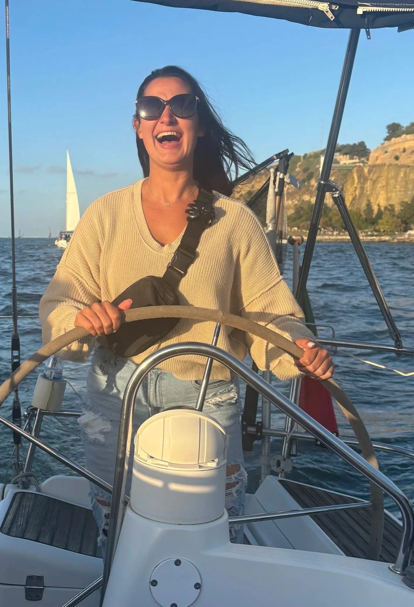 Young woman navigating life with confidence, joy and radiance. She is sailing a boat