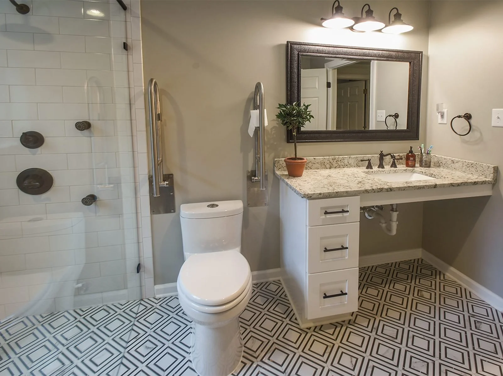Luxury aging-in-place bathroom remodel with grab bars, curbless shower, comfort-height toilet, and accessible vanity by Robbins Construction.